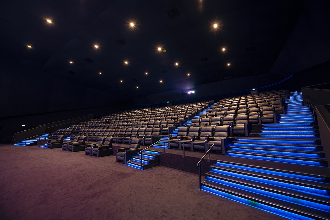 Grande salle de cinéma équipée de fauteuils en cuir noir et de la technologie Dolby.