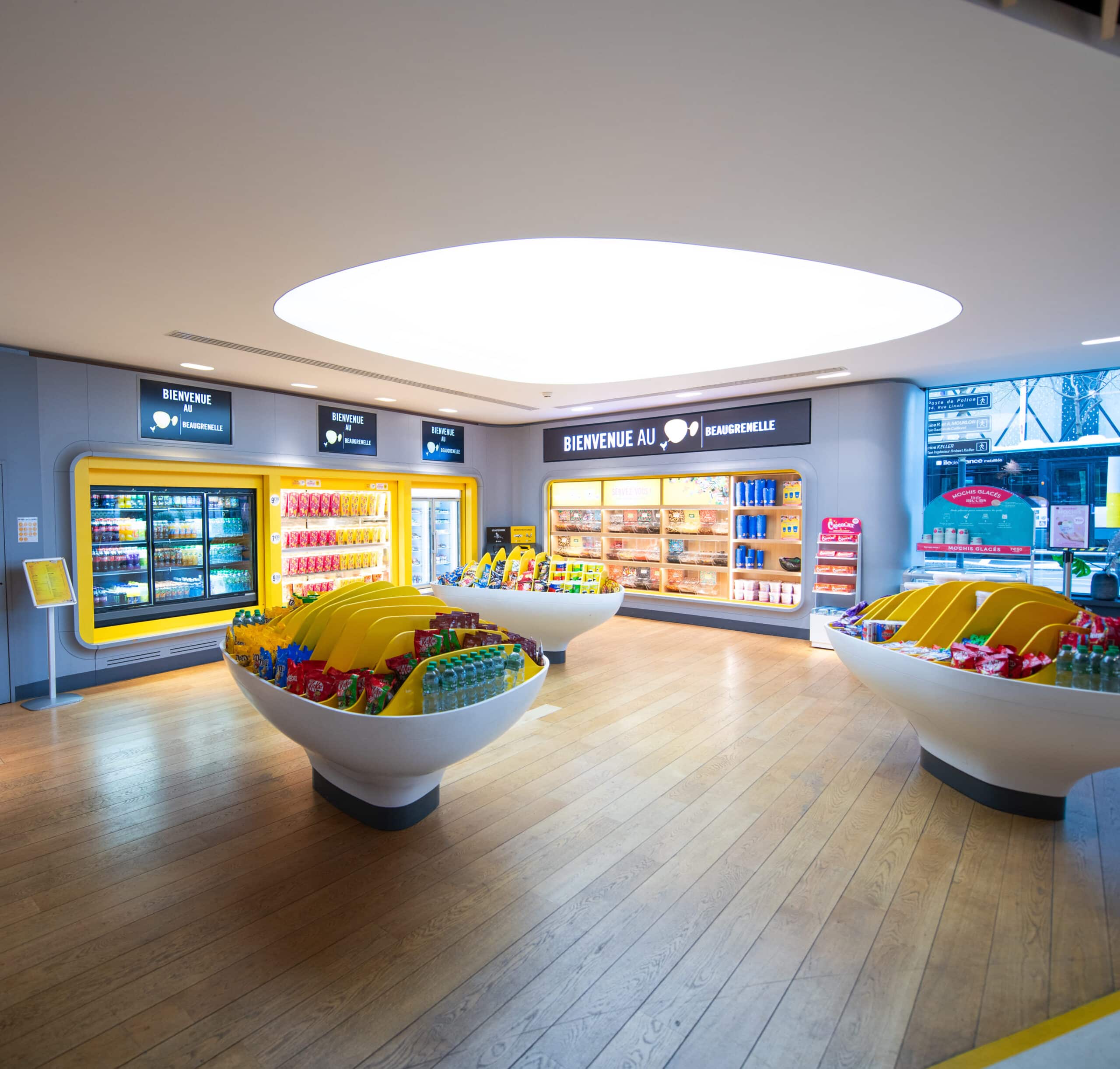 Espace confiserie du cinéma Pathé avec comptoir de pop-corn, distributeurs de boissons en libre-service et îlots de snacks et confiseries.