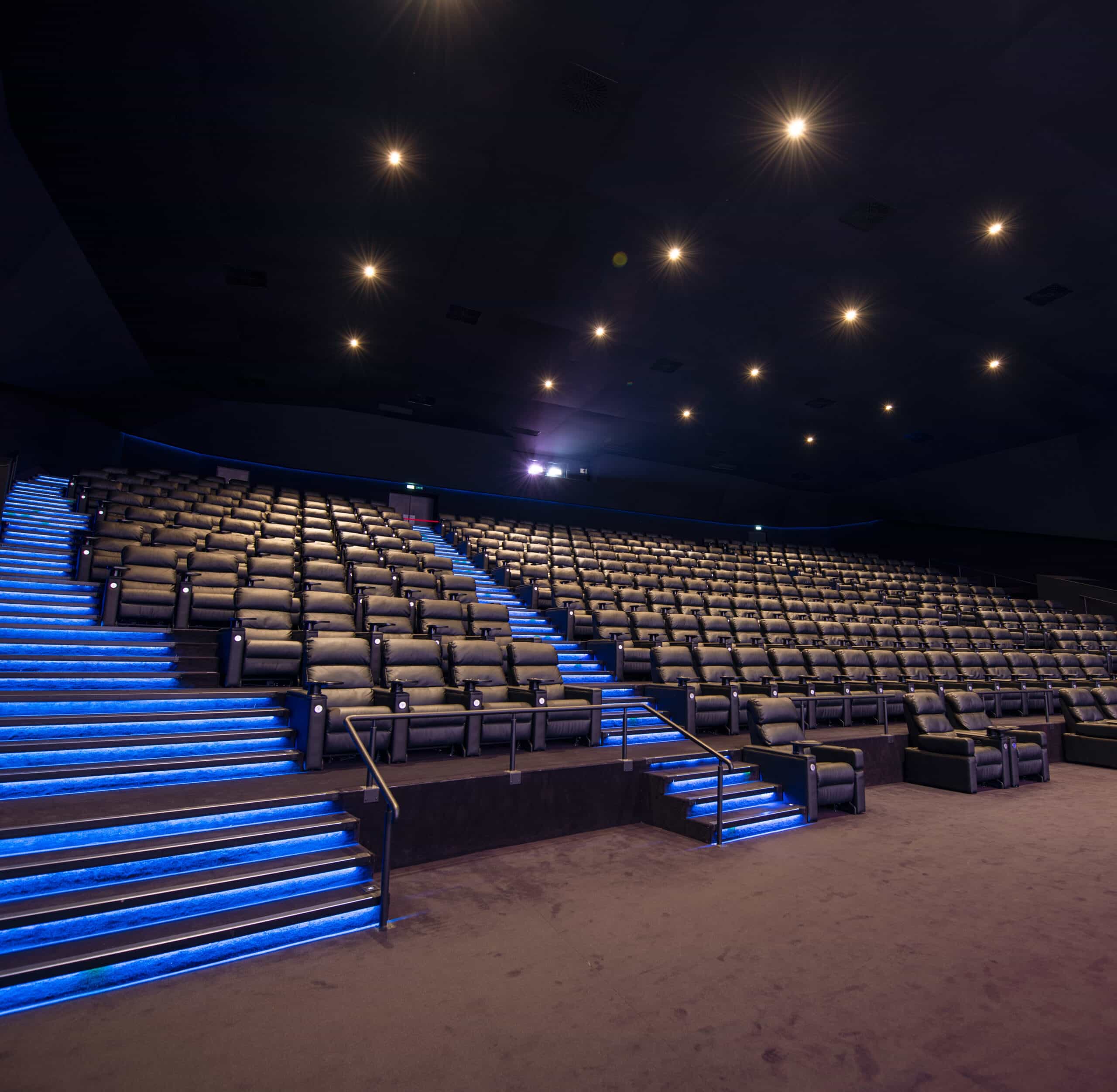 Grande salle de cinéma équipée de fauteuils en cuir noir et de la technologie Dolby.