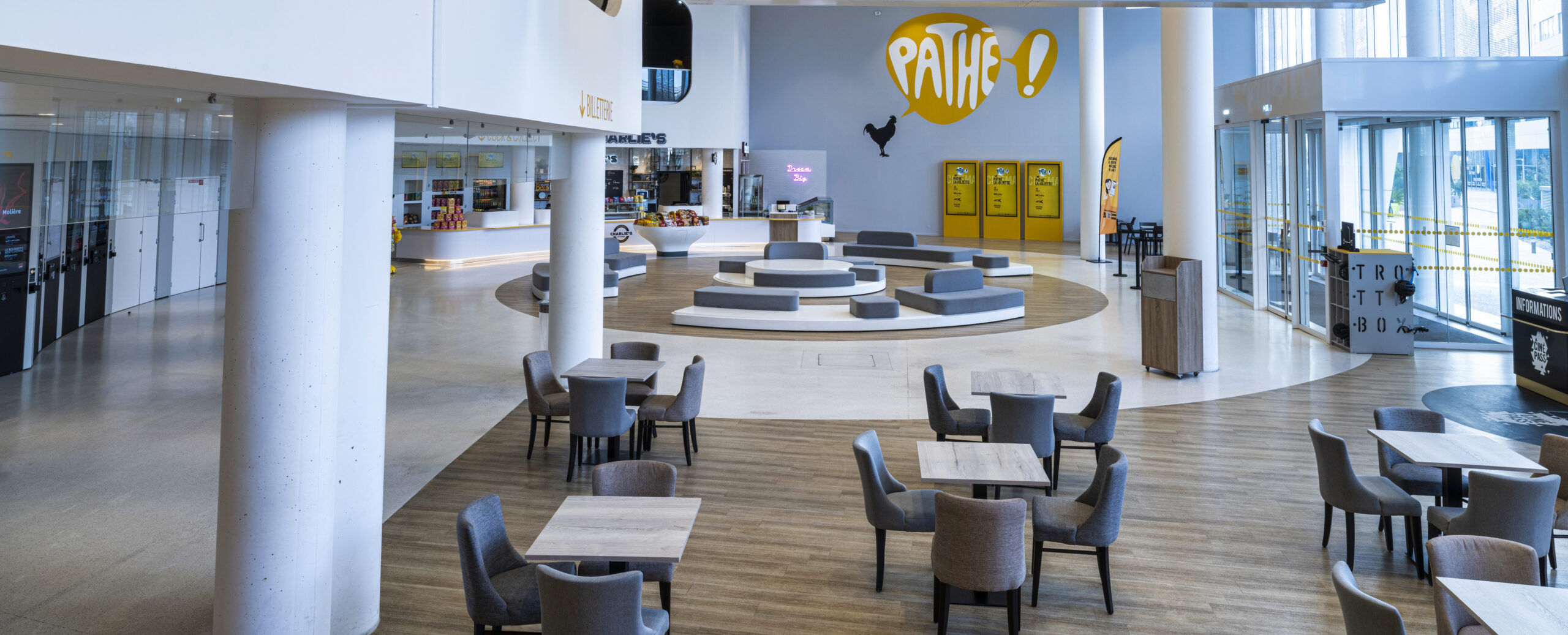 Grand espace de réception situé dans le hall du cinéma, baigné de lumière naturelle avec son mobilier de réception.