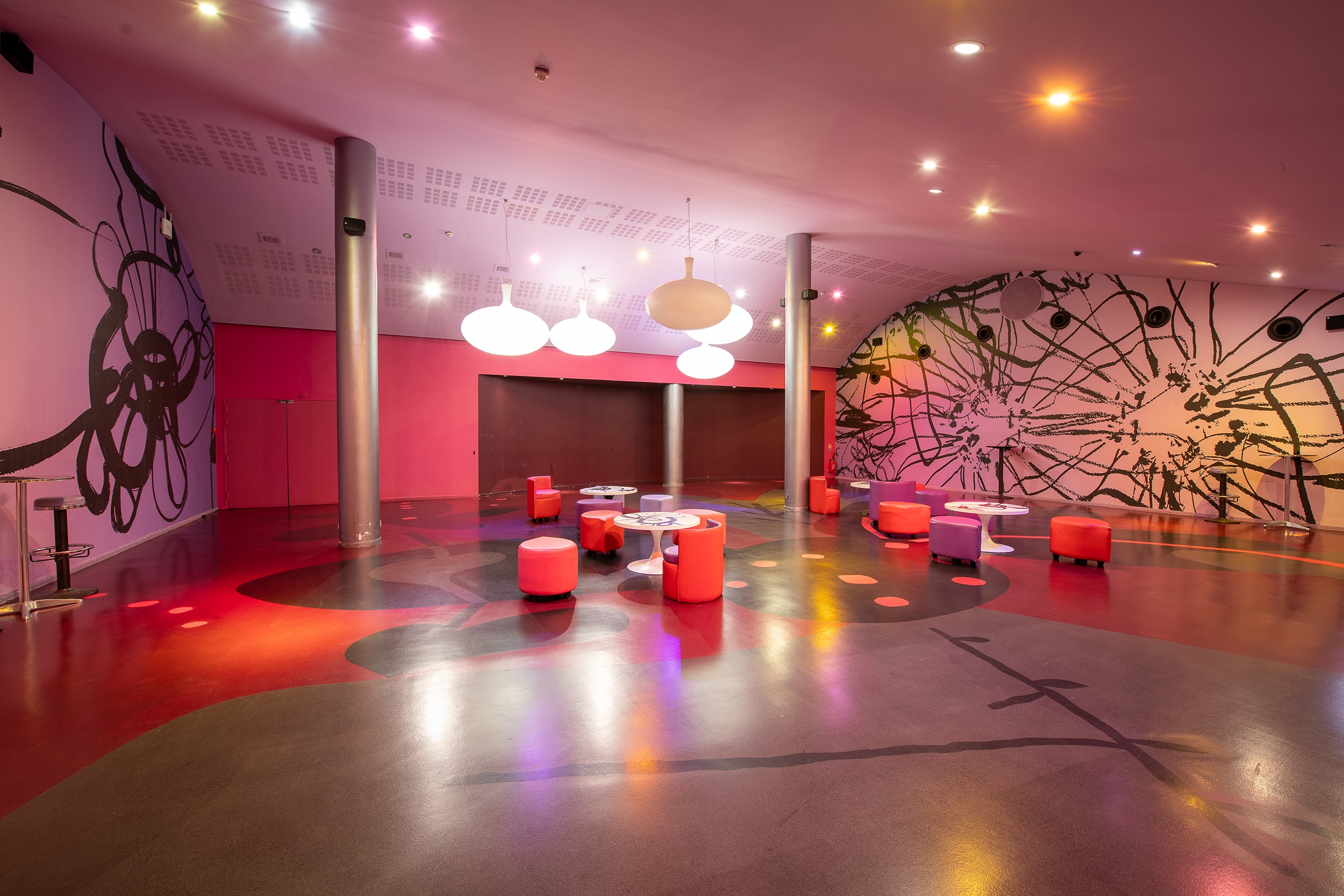 Espace cocktail du cinéma, équipé de tables, chaises et canapés, idéal pour des moments conviviaux et des réceptions.