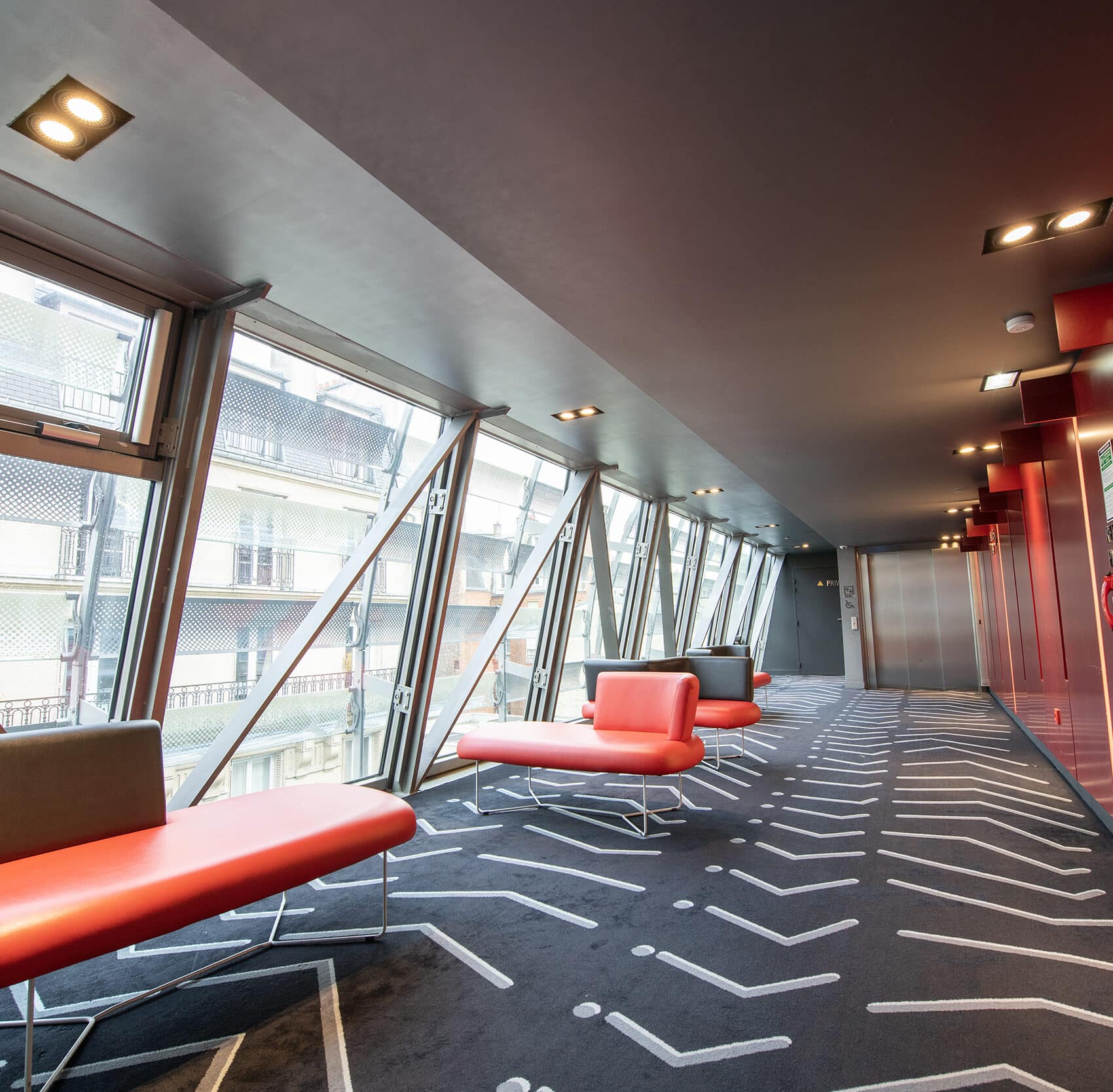Espace cocktail du cinéma, équipé de tables, chaises et canapés, idéal pour des moments conviviaux et des réceptions.
