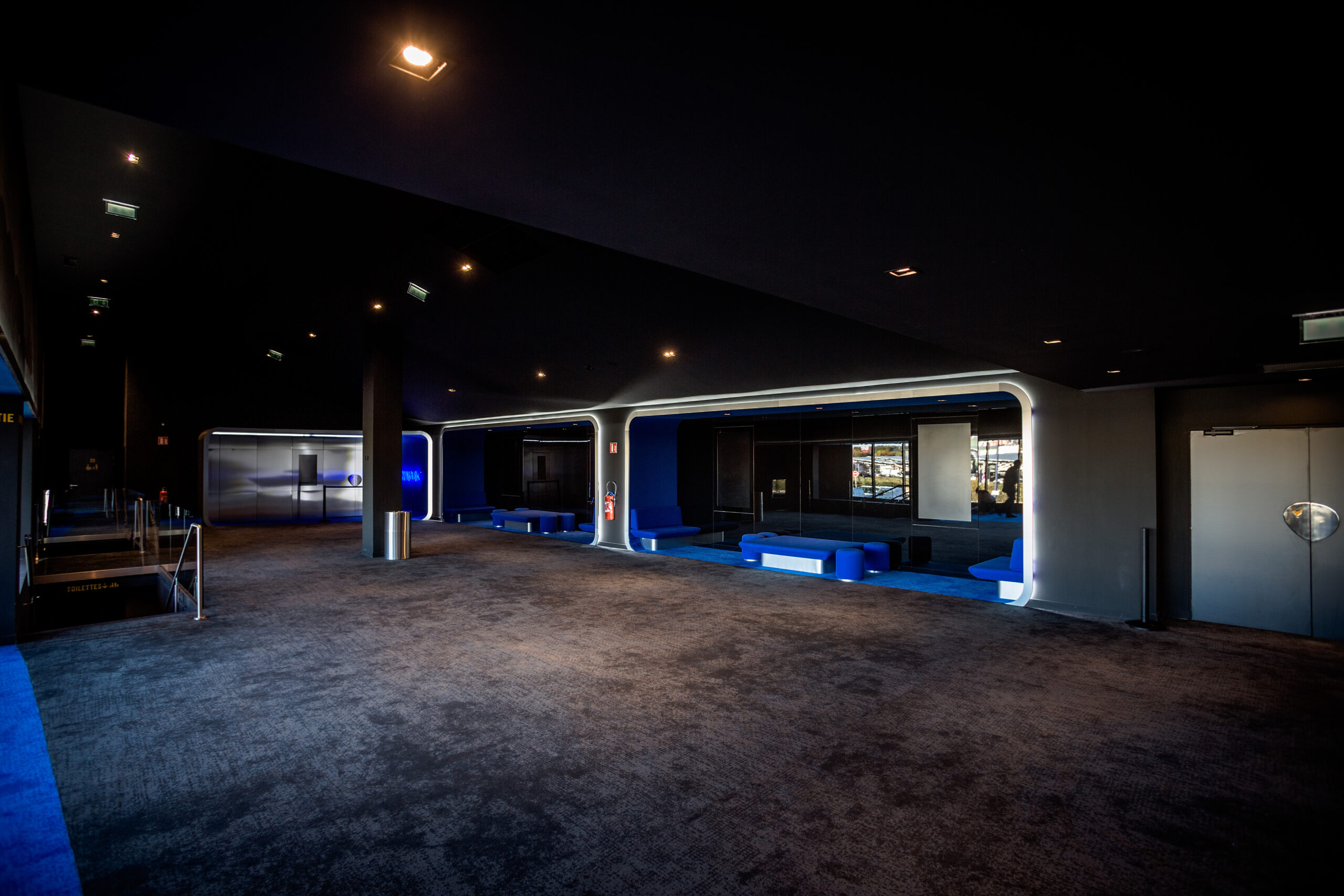 Espace cocktail du cinéma, équipé de tables, chaises et canapés, idéal pour des moments conviviaux et des réceptions.
