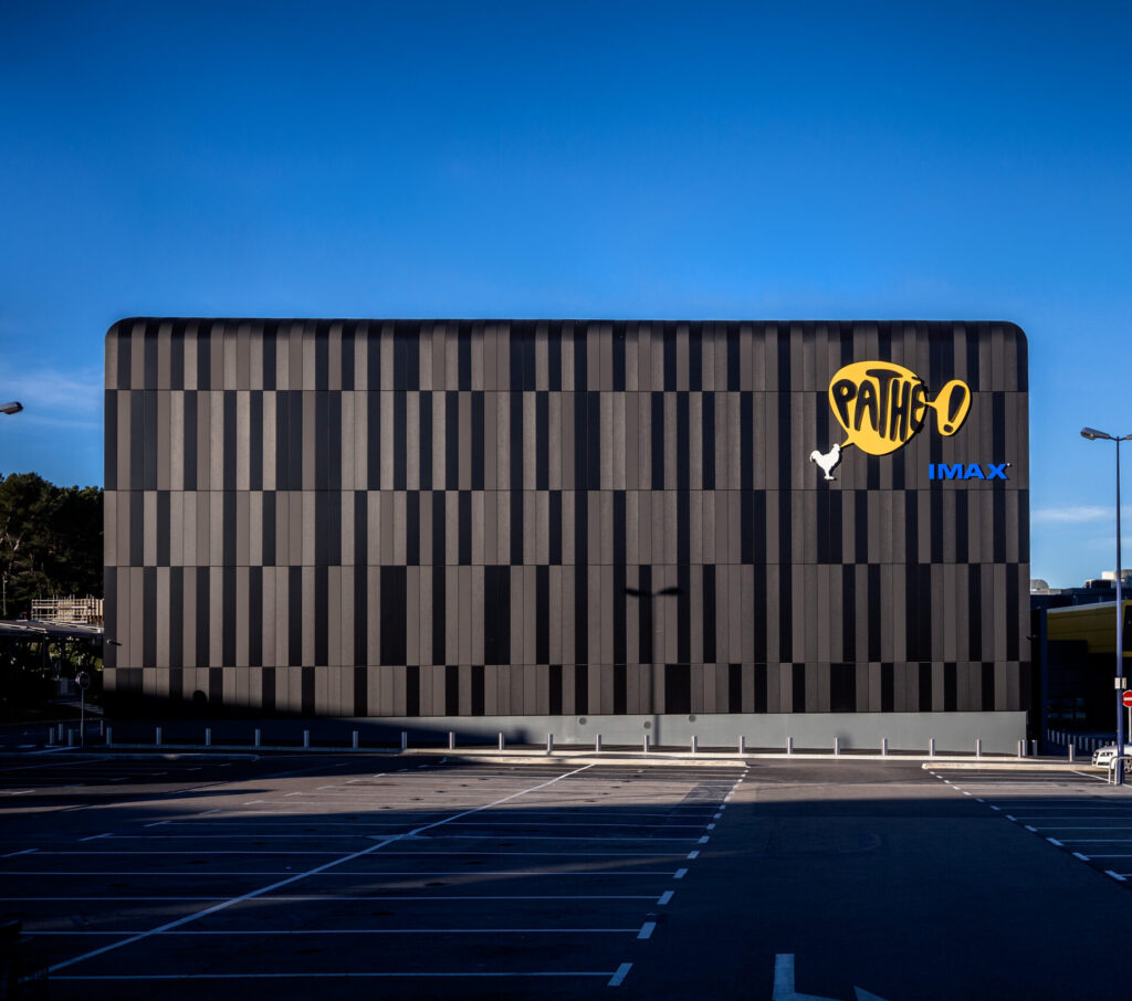 Façade extérieure du cinéma à la lumière du jour avec le logo Pathé apparent.