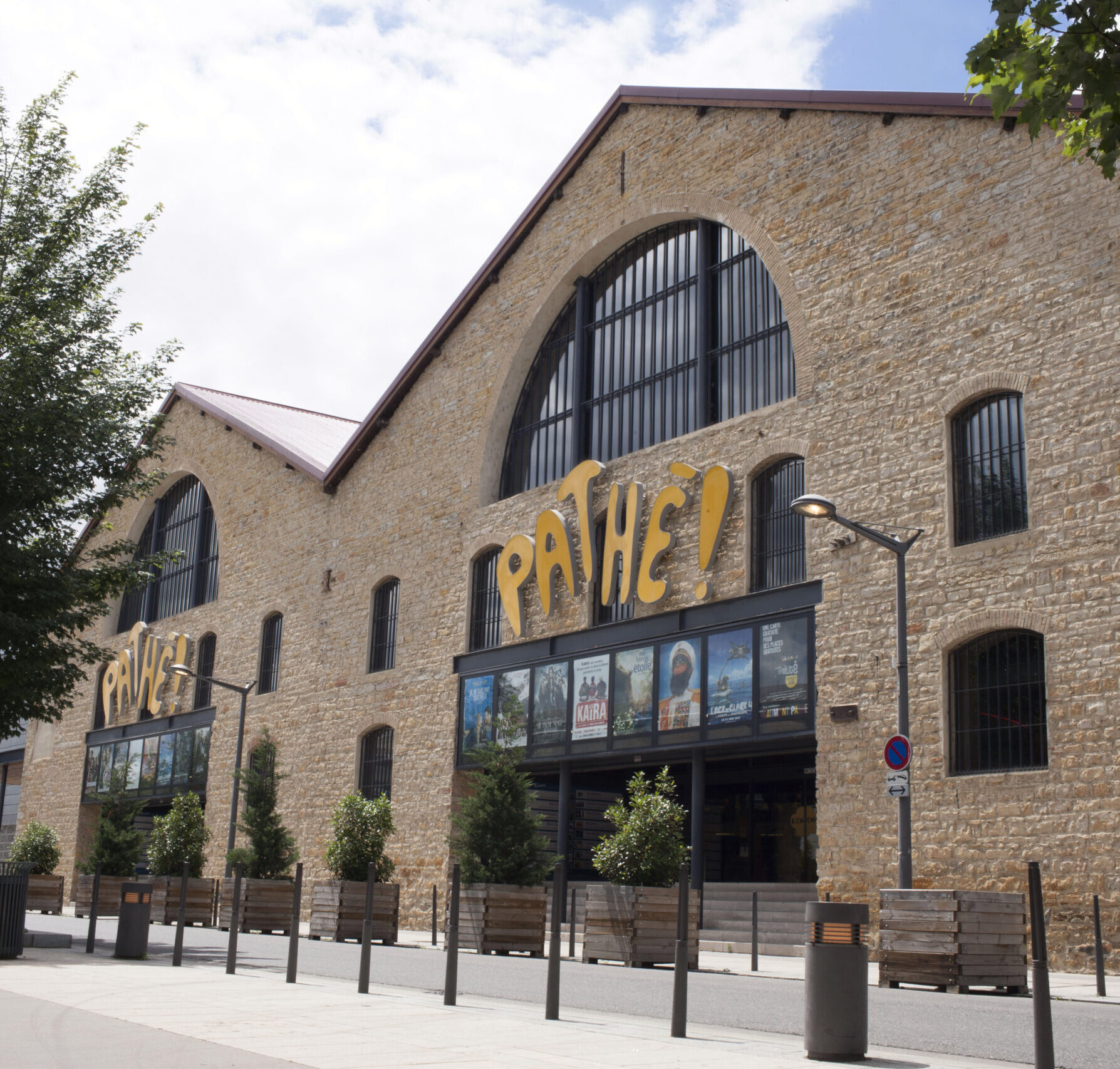 Façade extérieure du cinéma à la lumière du jour avec le logo Pathé apparent.