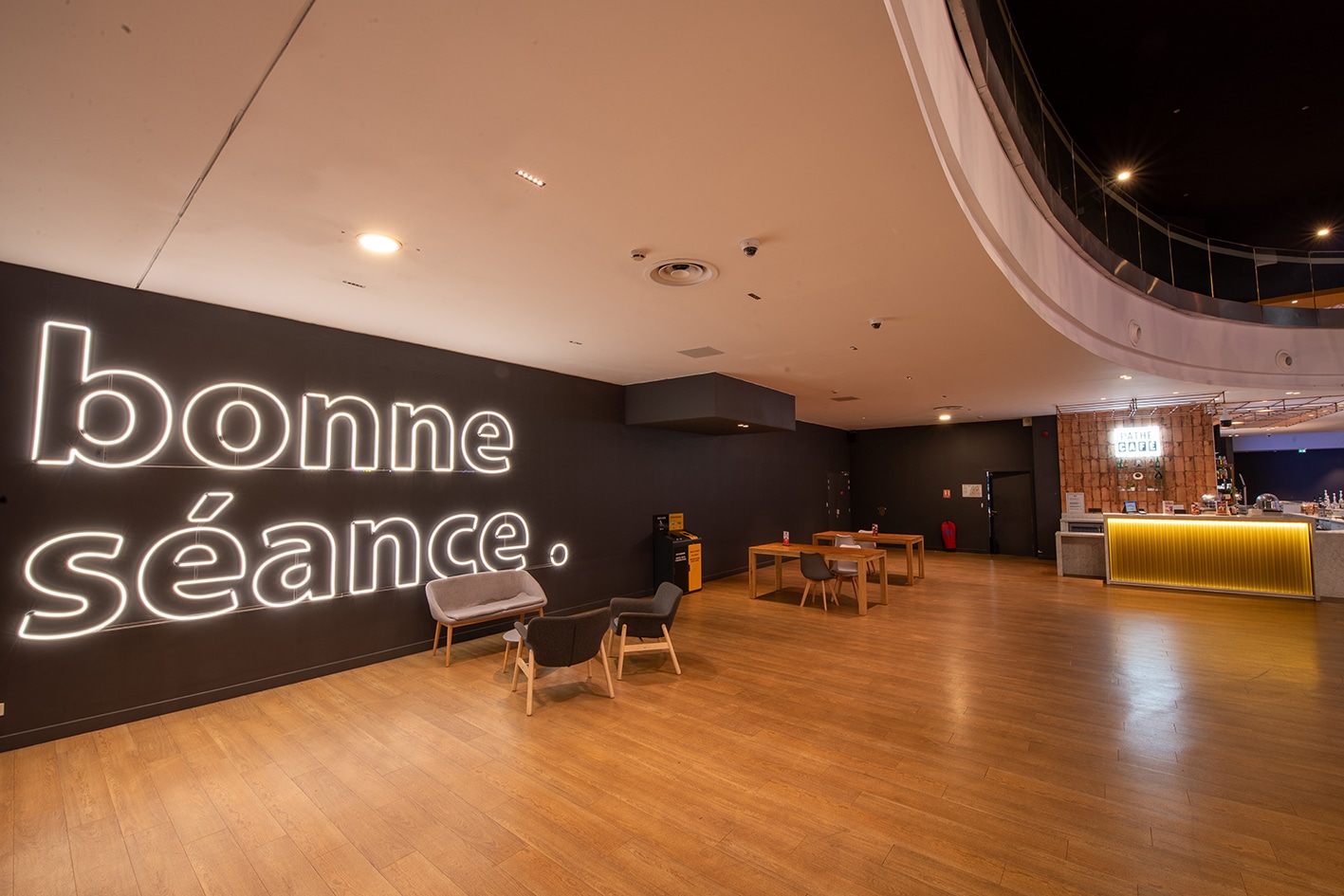 Espace cocktail du cinéma, équipé de tables, chaises et canapés, idéal pour des moments conviviaux et des réceptions.