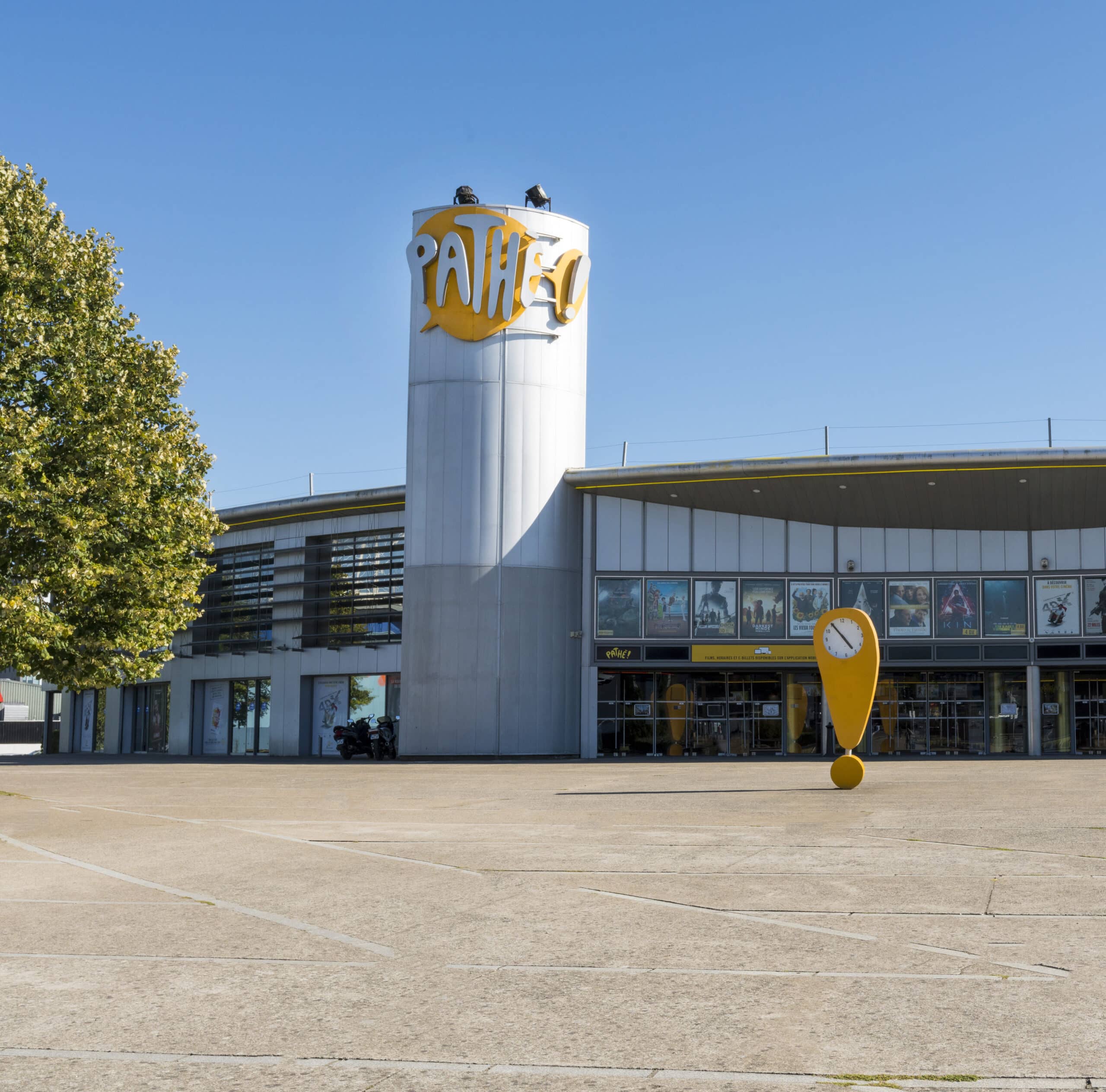 Façade extérieure du cinéma à la lumière du jour avec le logo Pathé apparent.