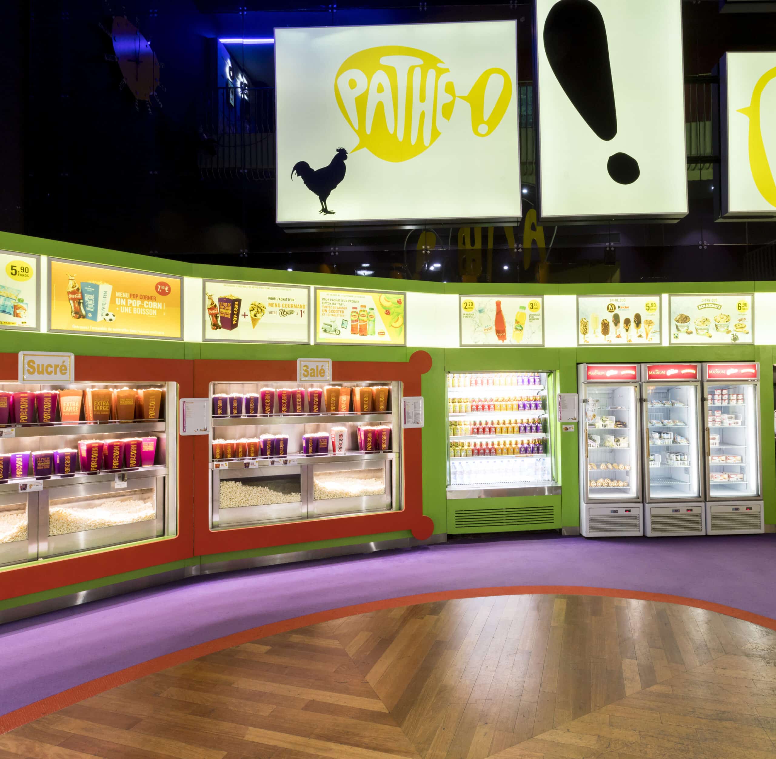 Espace confiserie du cinéma Pathé avec comptoir de pop-corn, distributeurs de boissons en libre-service.