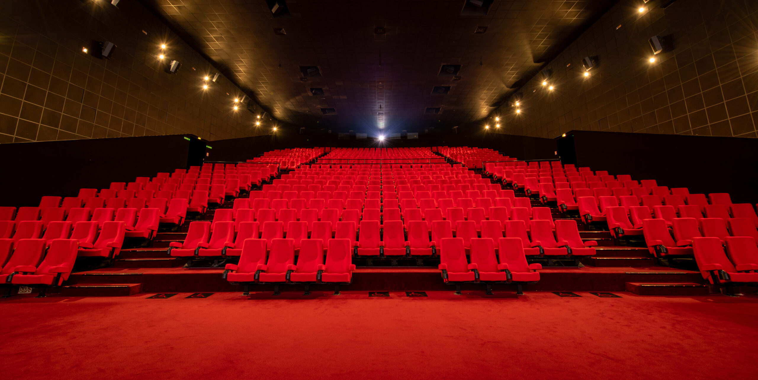 Salle 1 de 615 places avec fauteuils en velours rouges du Pathé Disney Village