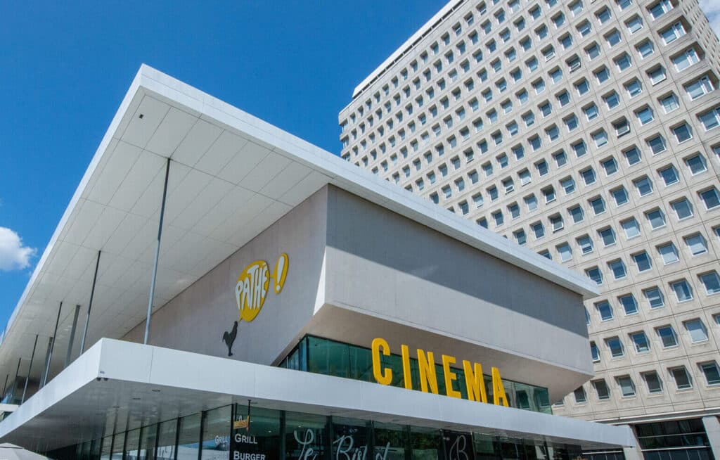 Façade extérieure du cinéma à la lumière du jour avec le logo Pathé apparent.