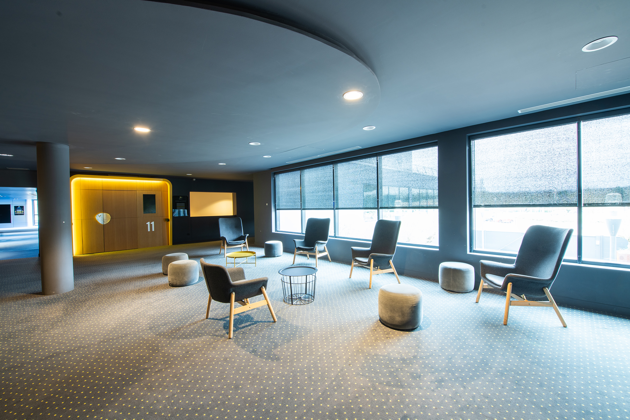 Espace cocktail du cinéma, équipé de tables, chaises et canapés, idéal pour des moments conviviaux et des réceptions.