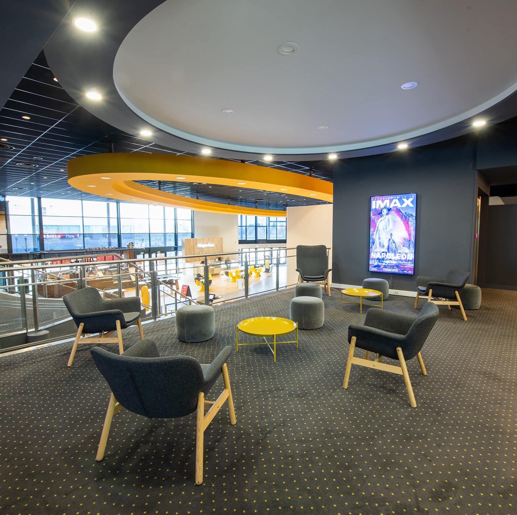 Espace cocktail du cinéma, équipé de tables, chaises et canapés, idéal pour des moments conviviaux et des réceptions.