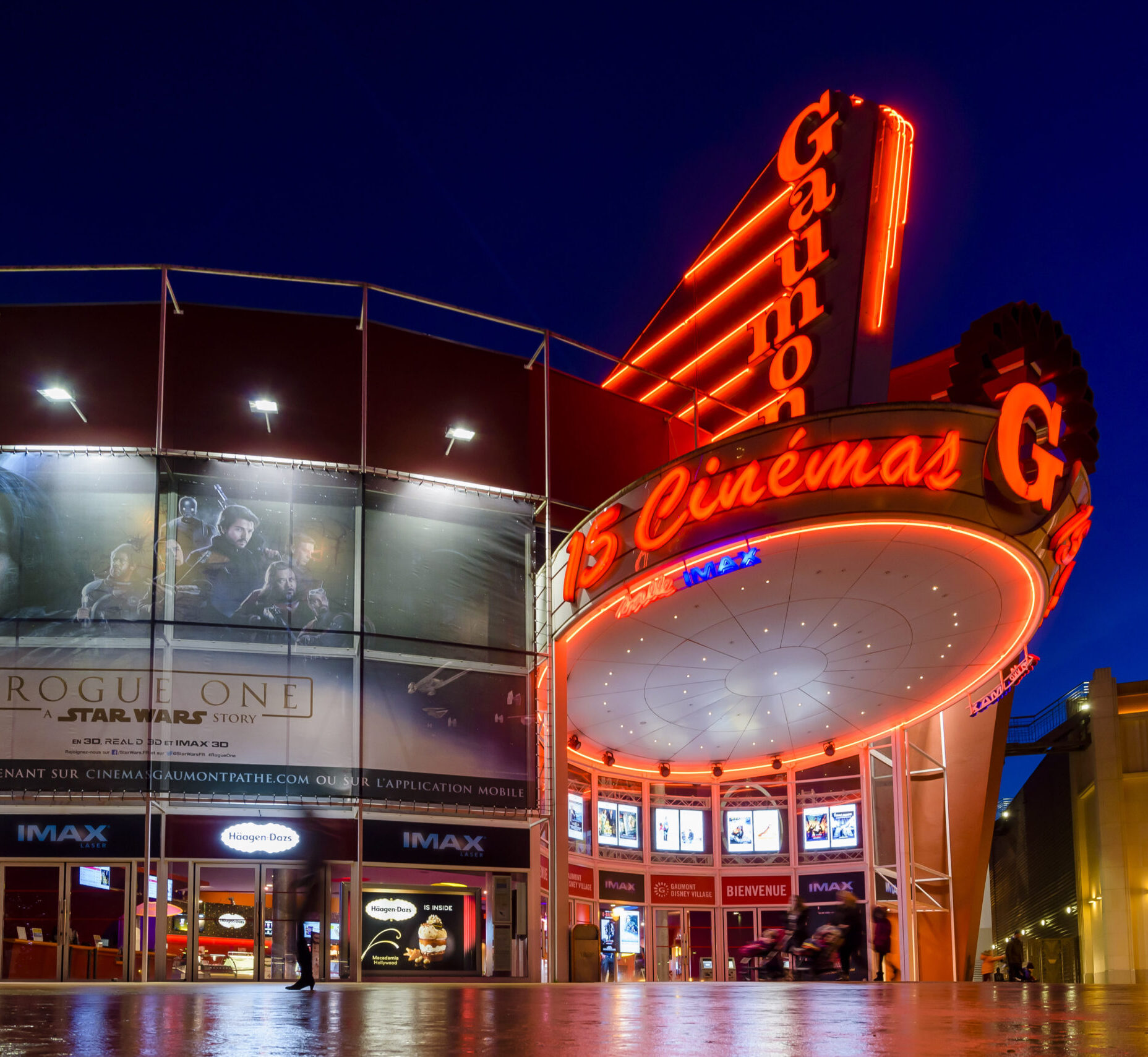 Façade extérieure du cinéma éclairée à la tombée de la nuit.