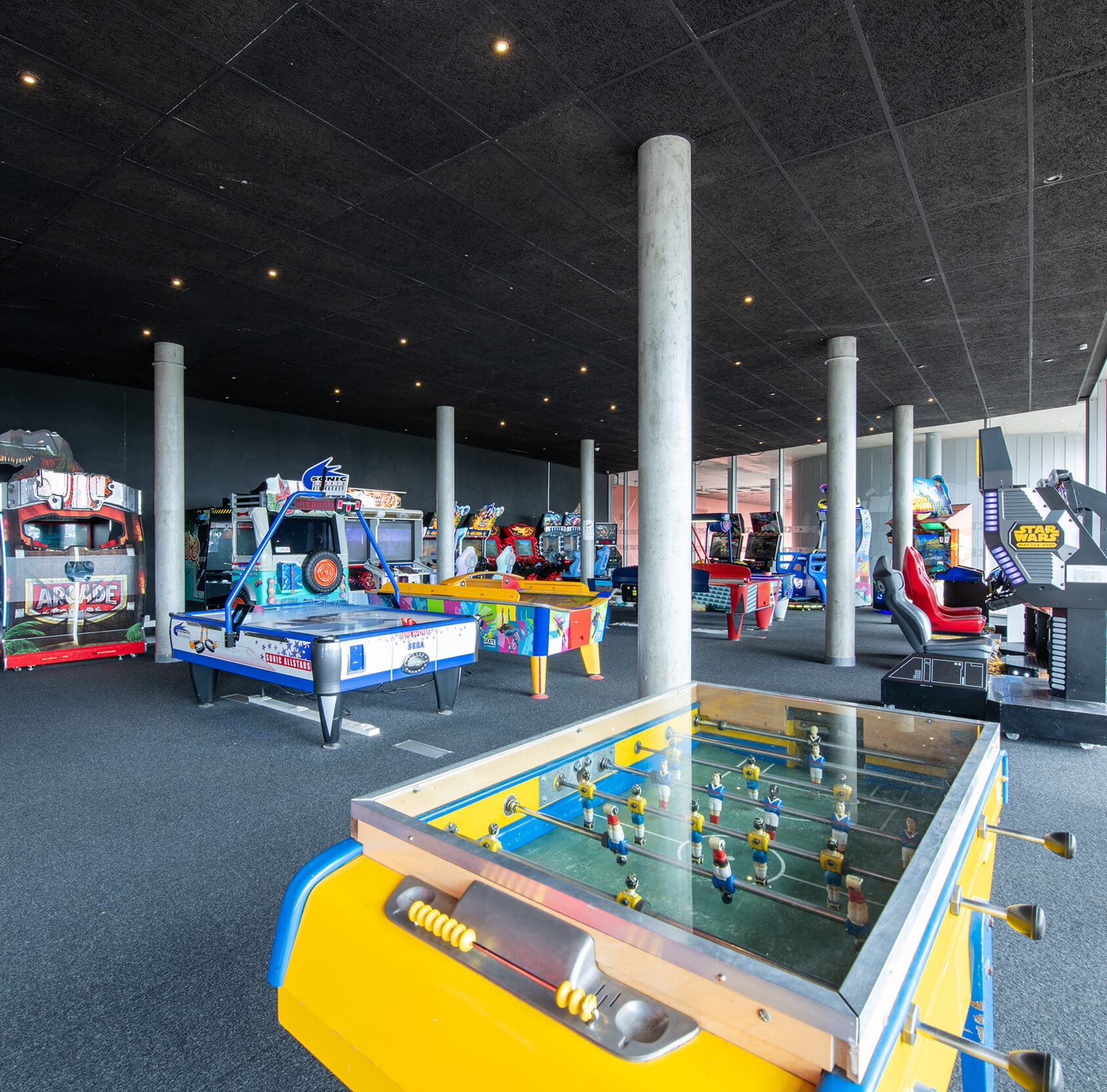 Espace Pathé Games avec différentes machines d’arcade et de jeux vidéo, éclairage lumineux, ambiance moderne et ludique, proposant des jeux pour tous les âges dans un cadre convivial.