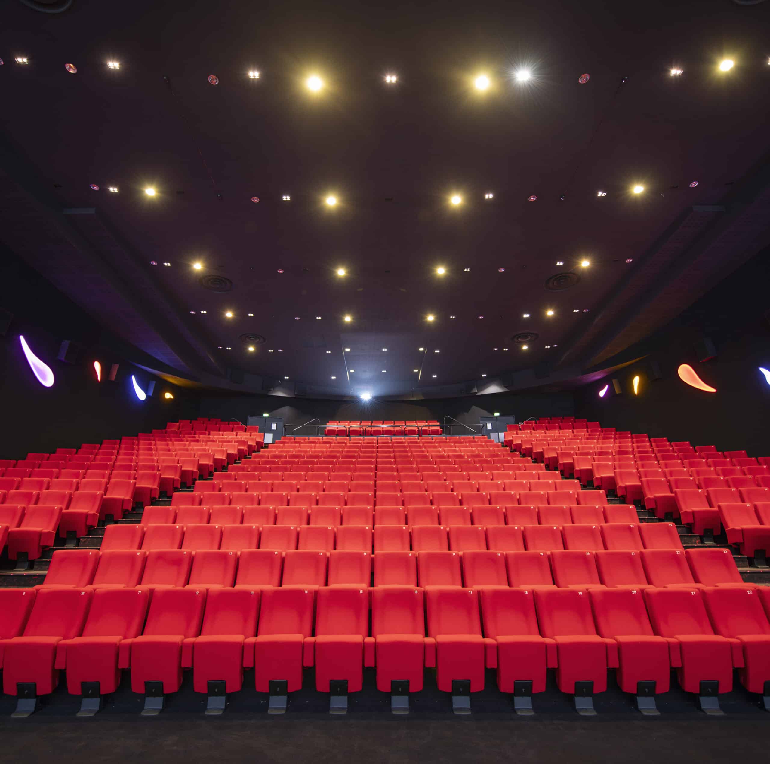 Vu d'ensemble de face d'une salle de cinéma Pathé avec ses fauteuils en velours rouge.