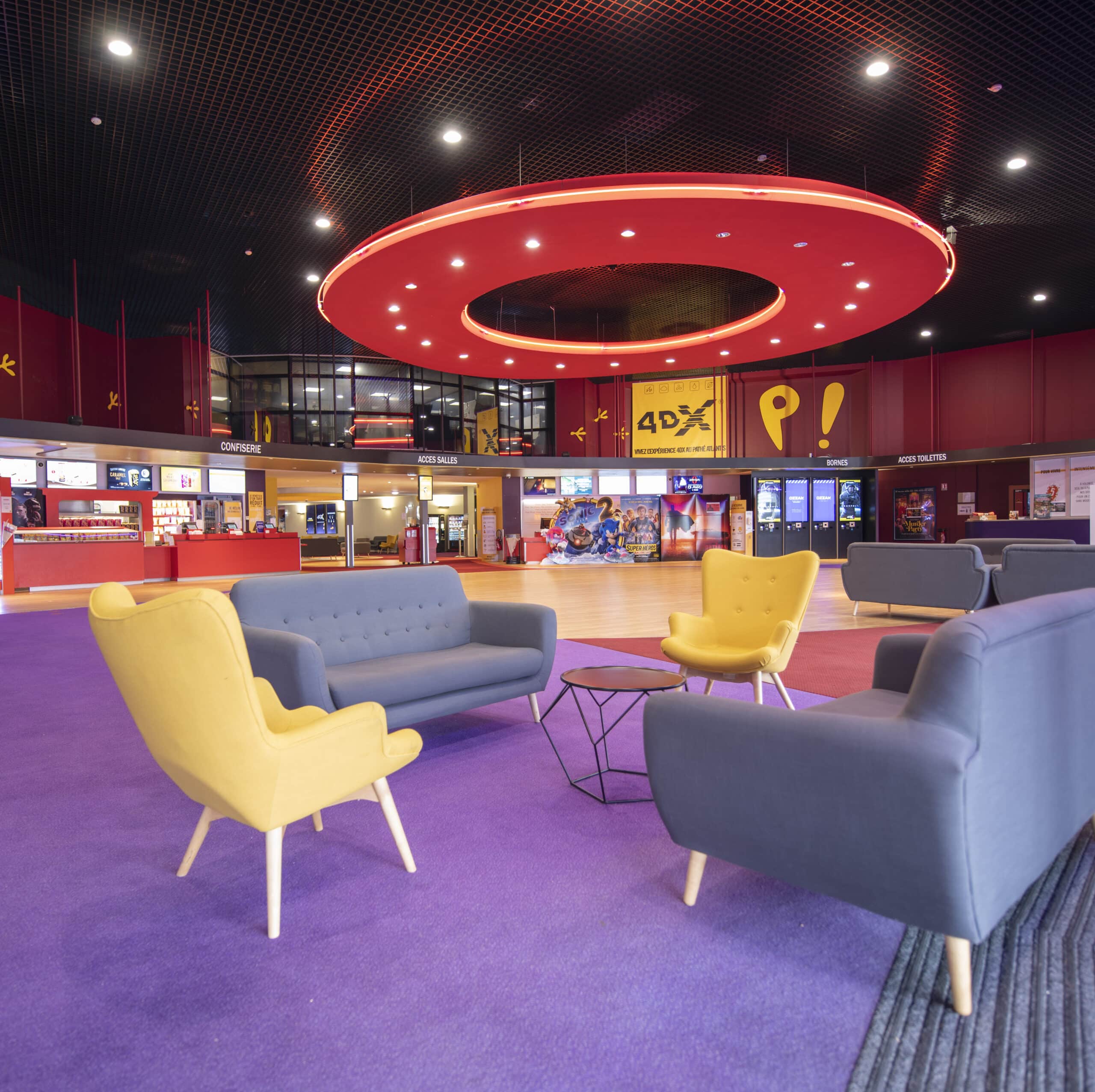 Espace cocktail du cinéma à la lumière du jour situé dans le hall d'accueil, équipé d'un mobilier de réception, idéal pour des moments conviviaux et des réceptions.