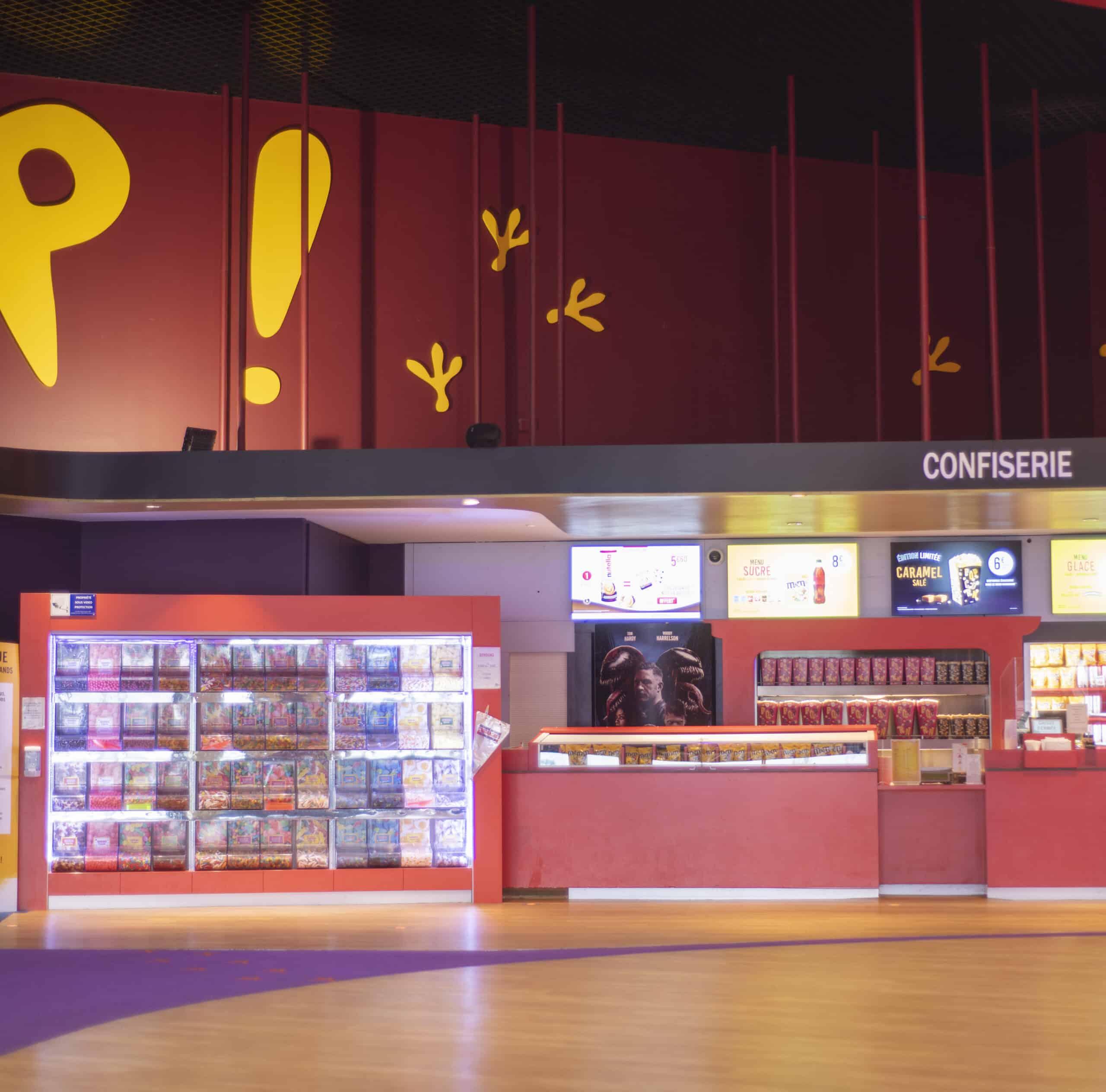 Espace confiserie du cinéma Pathé avec comptoir de pop-corn, distributeurs de boissons en libre-service.