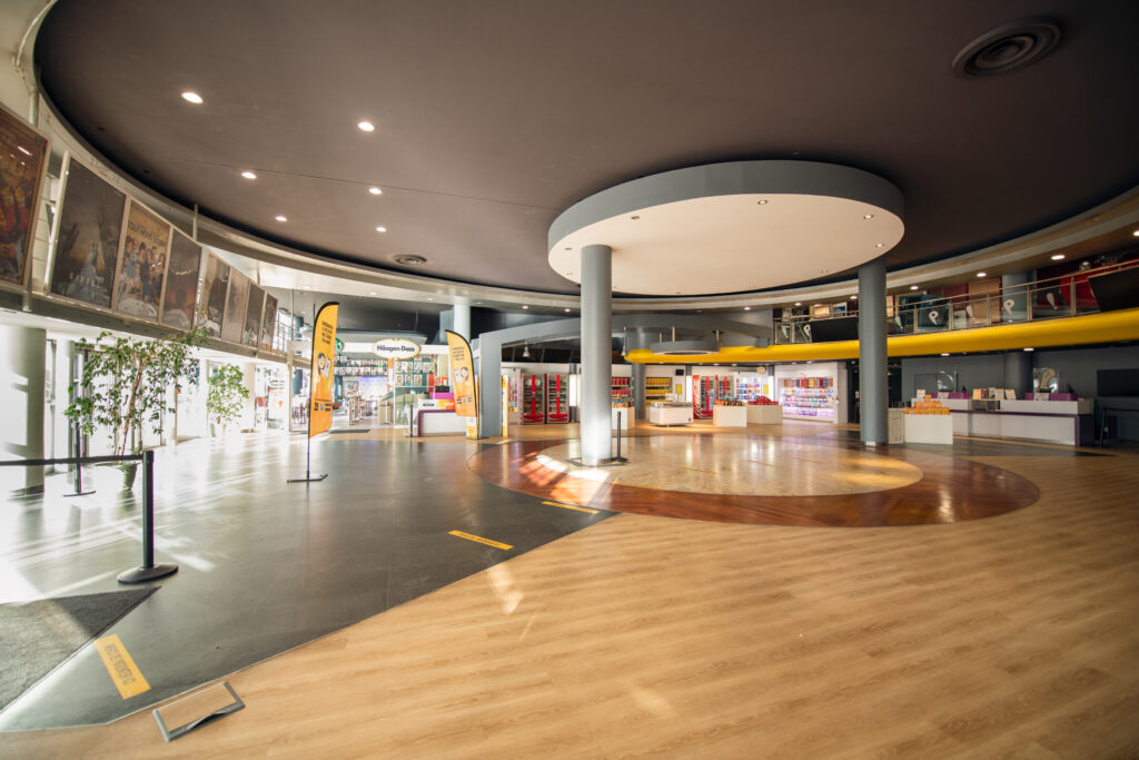 Grand espace de réception situé dans le hall du cinéma, baigné de lumière naturelle.