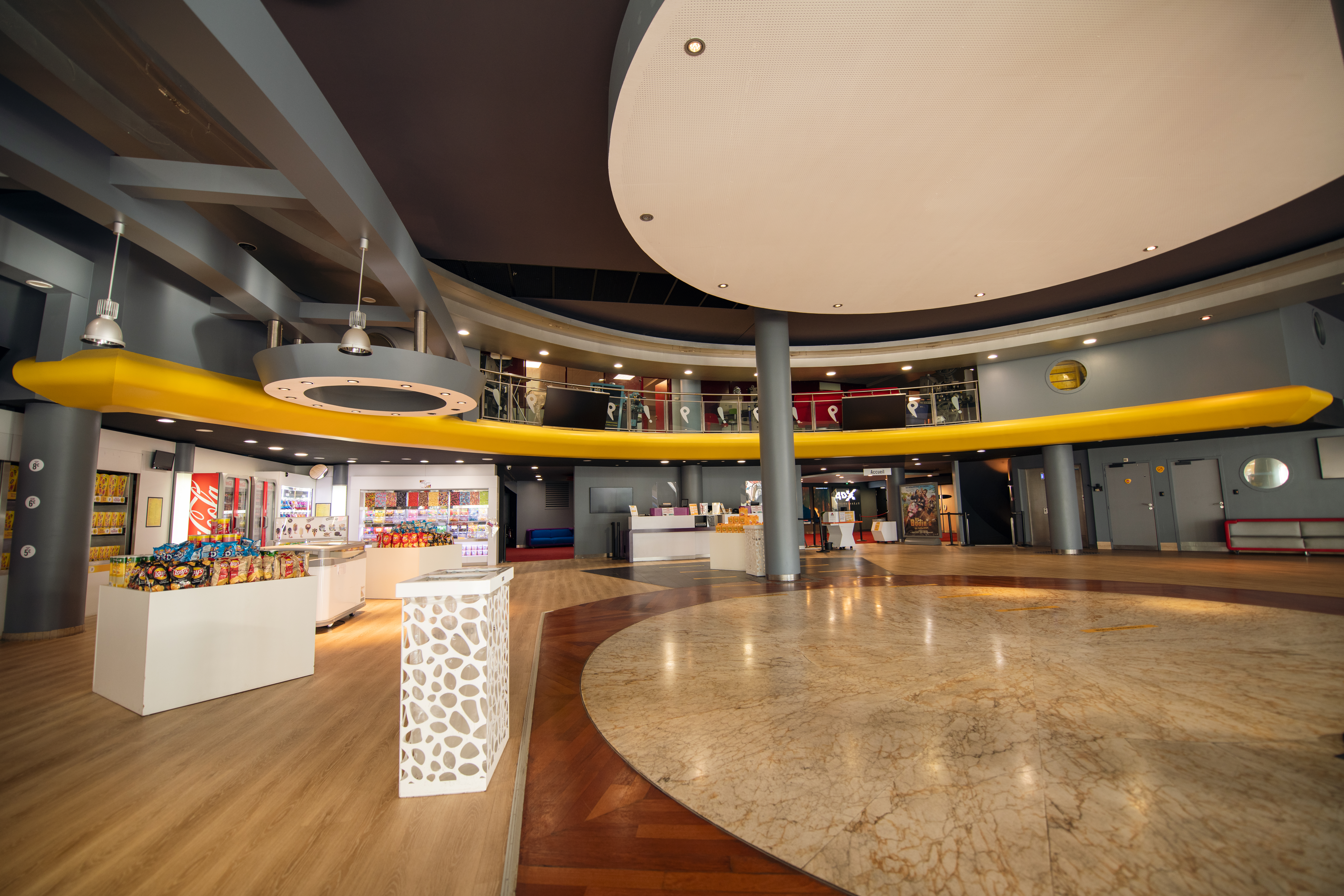 Grand espace de réception situé dans le hall du cinéma, baigné de lumière naturelle.