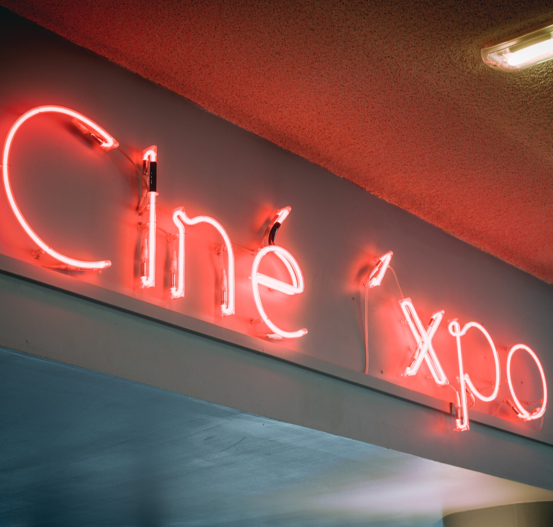 Enseigne lumineuse « Ciné » en néon rouge dans le cinéma.