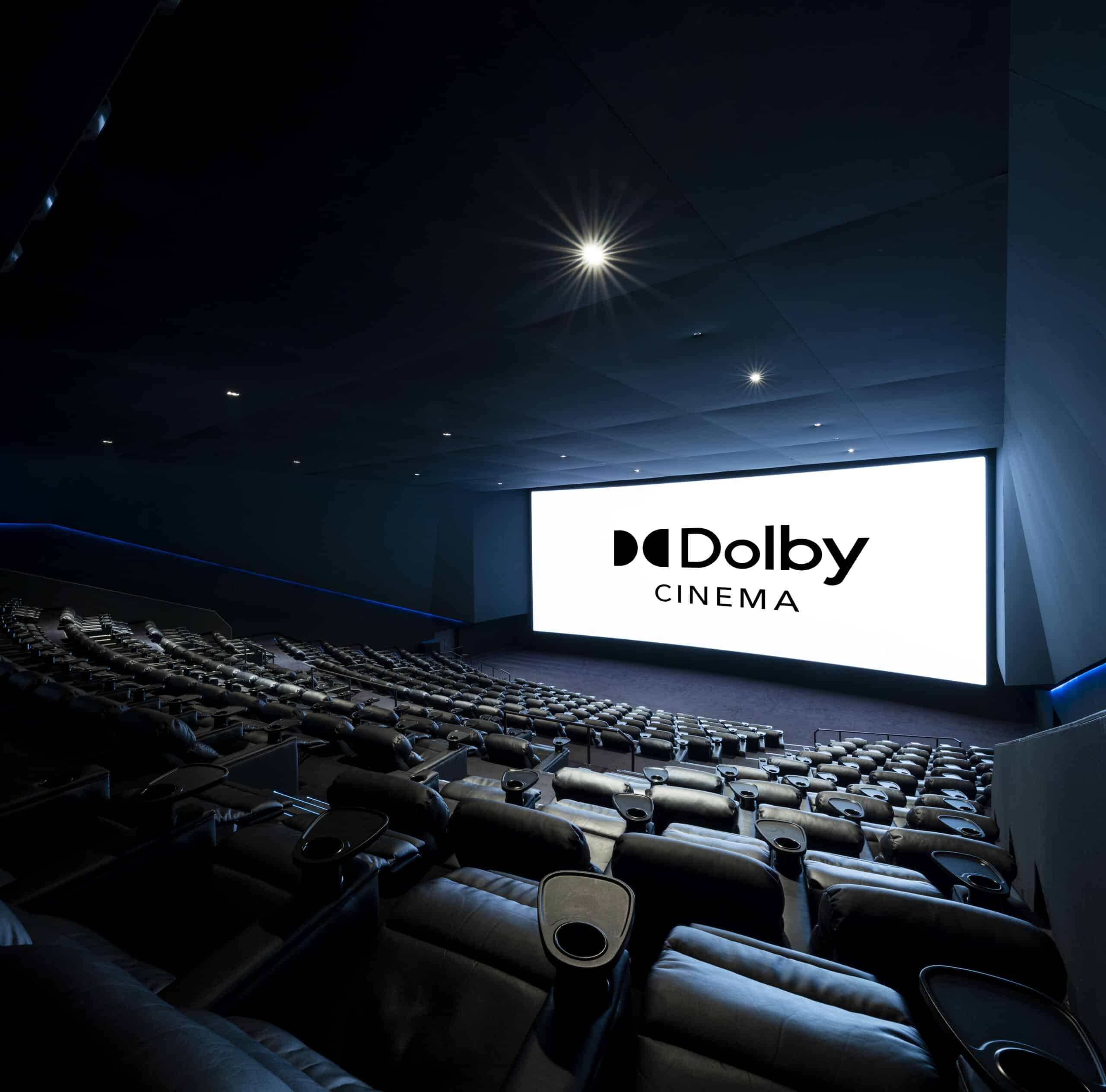 Grande salle de cinéma équipée de fauteuils en cuir noir et de la technologie Dolby Cinéma..