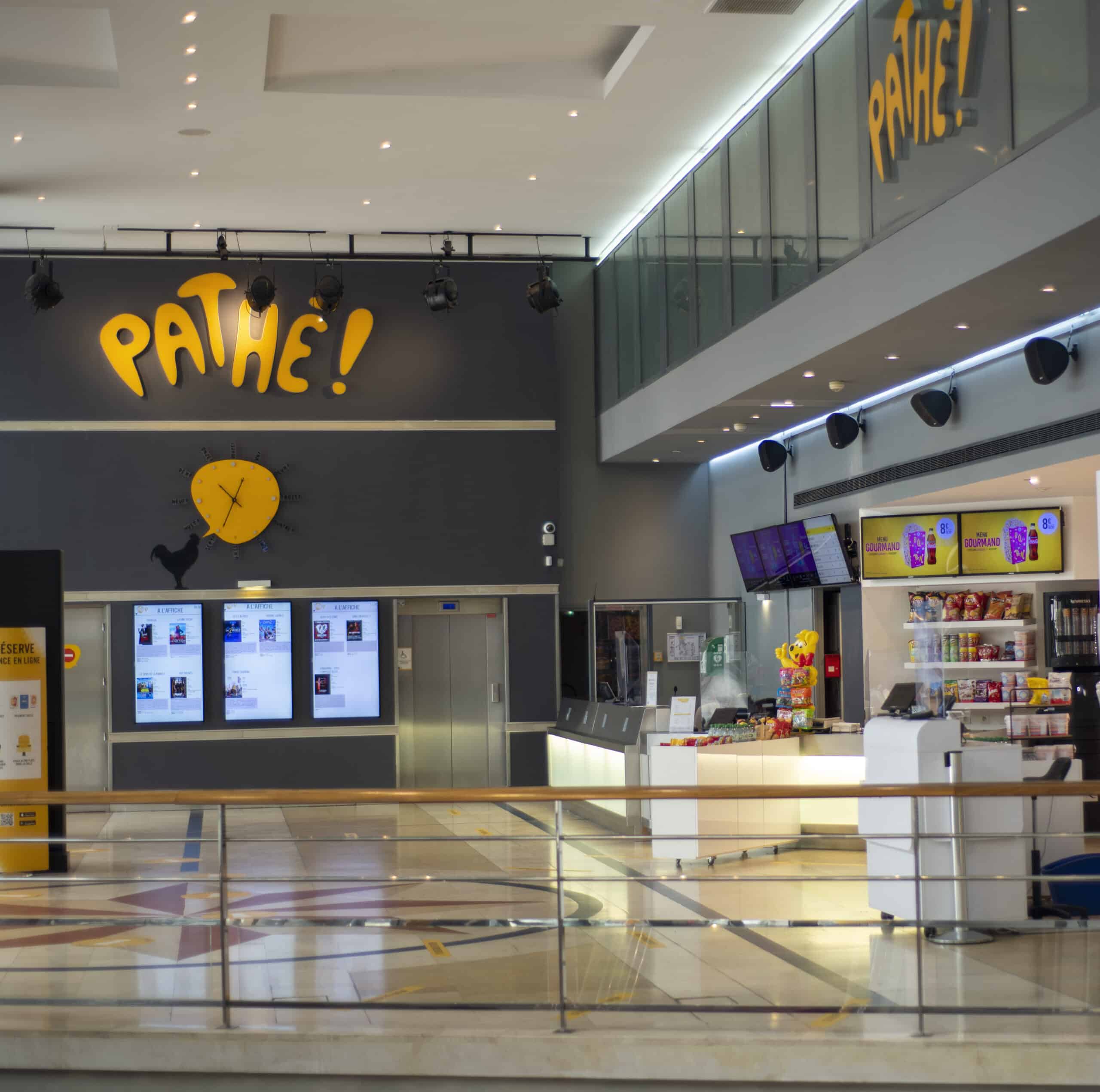 Hall du cinéma Pathé Boulgone à Paris ou l'on peut distinguer l'espace confiserie, l'enseigne ainsi que les bornes de réservation.