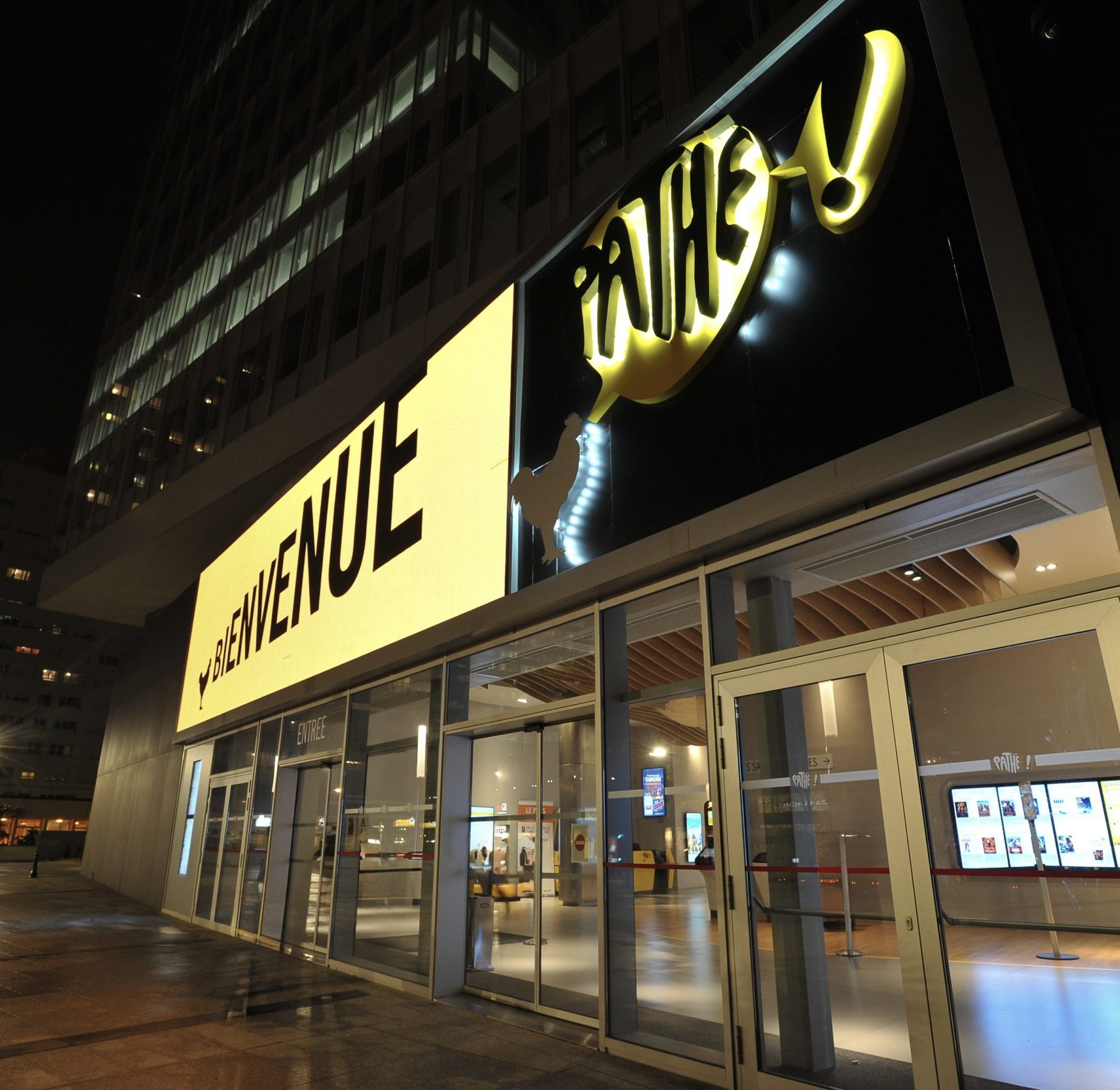 Façade extérieure du cinéma éclairée à la tombée de la nuit.