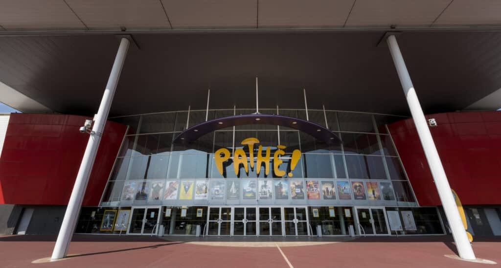 Façade extérieure du cinéma à la lumière du jour avec le logo Pathé apparent.