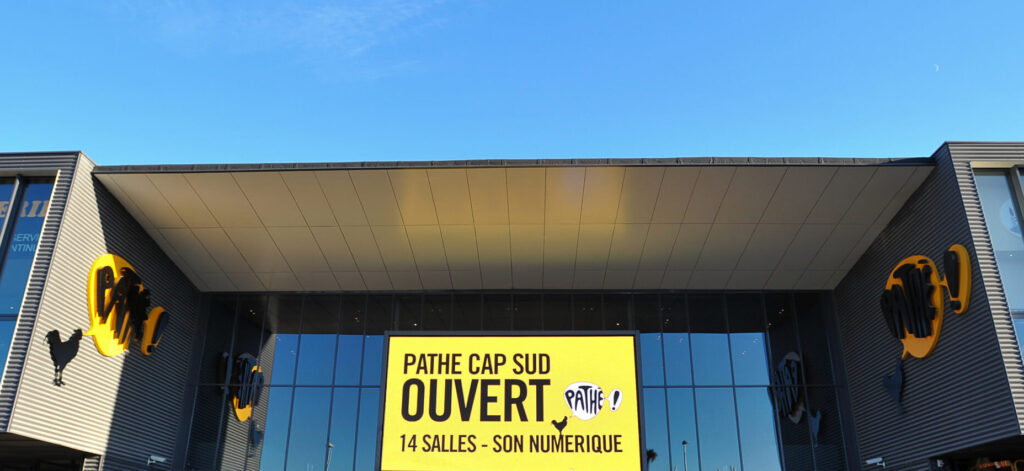 Façade extérieure du cinéma à la lumière du jour avec le logo Pathé apparent.