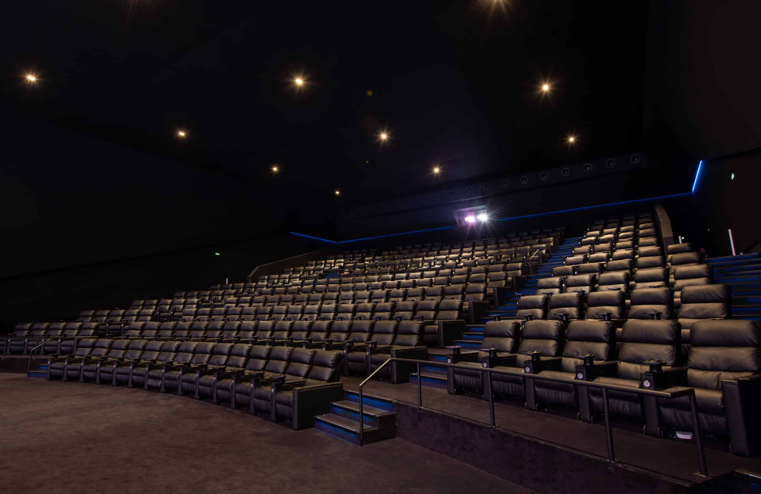 Grande salle de cinéma équipée de fauteuils en cuir noir et de la technologie Dolby.