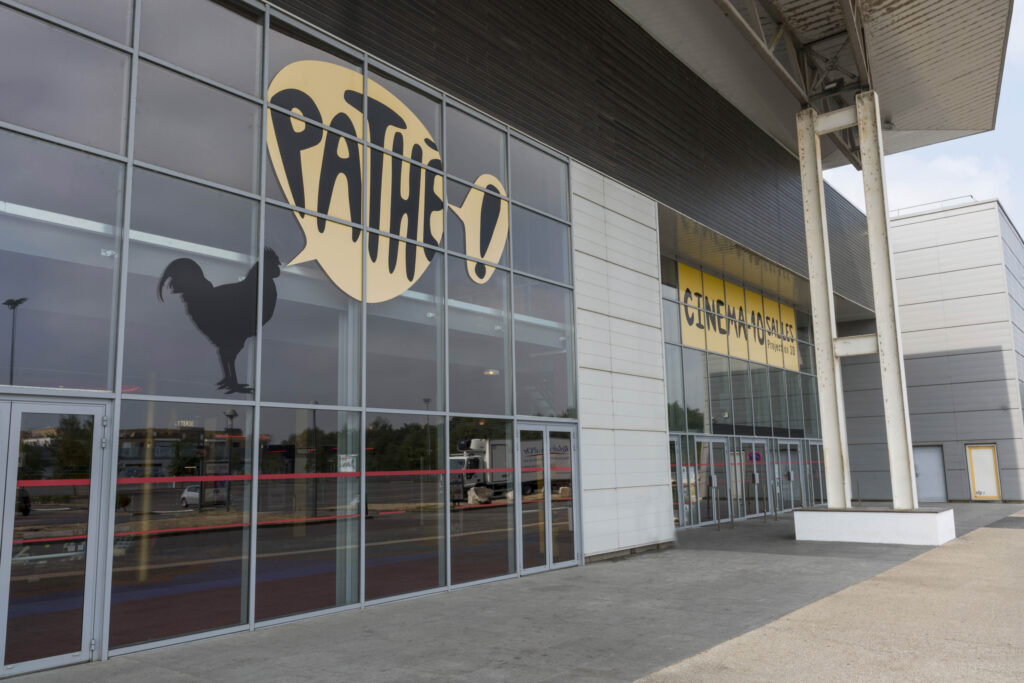 Façade extérieure du cinéma à la lumière du jour avec le logo Pathé apparent.
