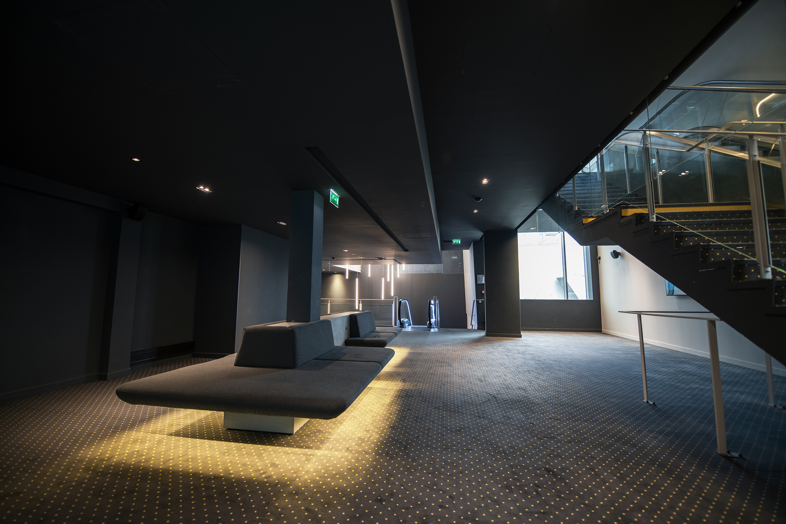 Espace cocktail du cinéma, équipé de tables, chaises et canapés, idéal pour des moments conviviaux et des réceptions.