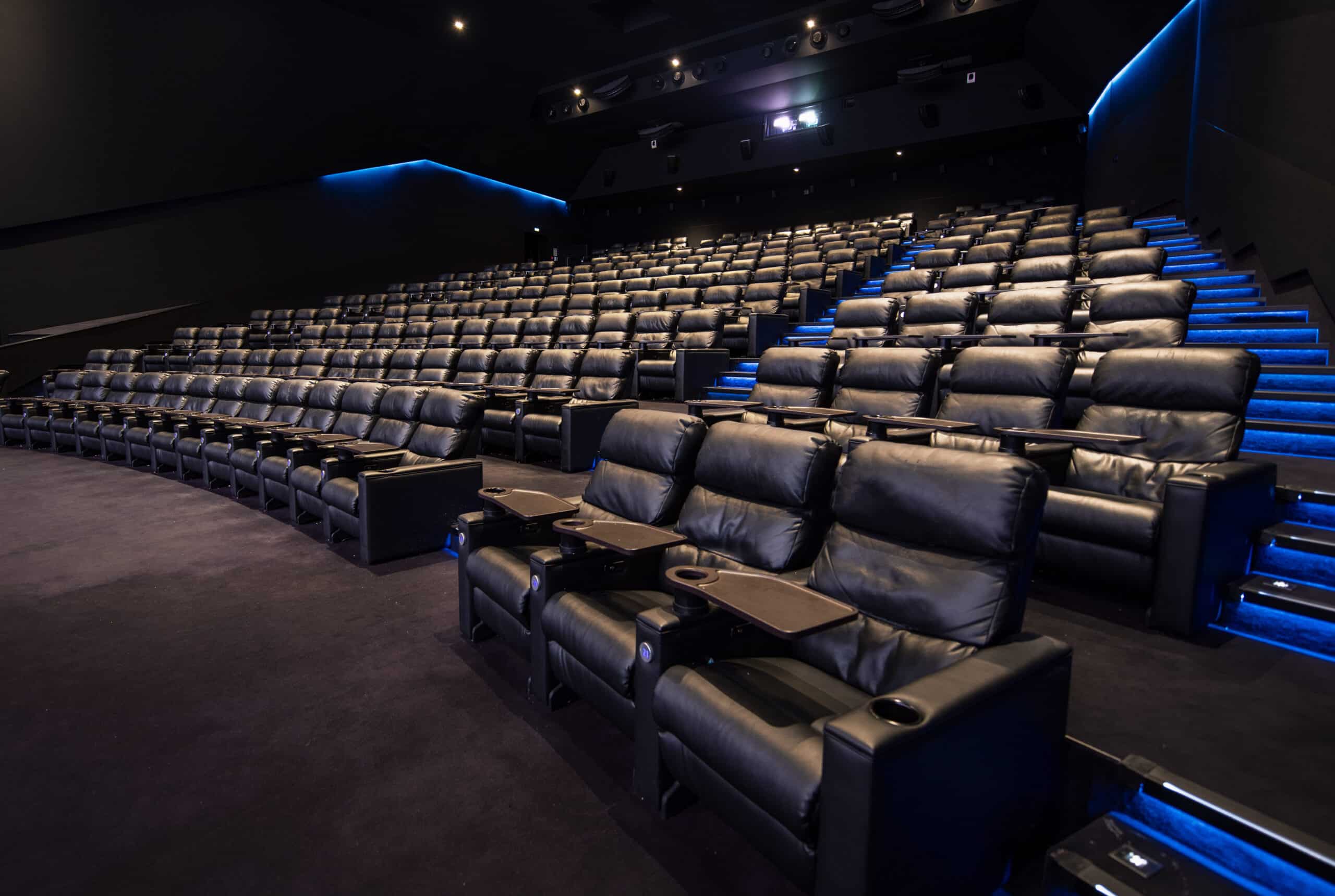 Grande salle de cinéma équipée de fauteuils en cuir noir et de la technologie Dolby.