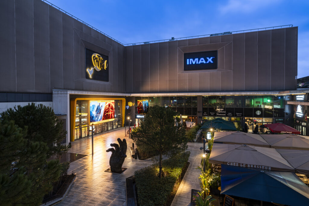 Façade extérieure du cinéma éclairée à la tombée de la nuit.