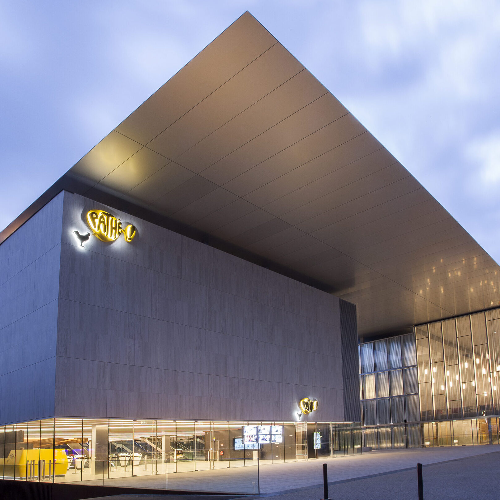 Façade extérieure du cinéma éclairée à la tombée de la nuit.