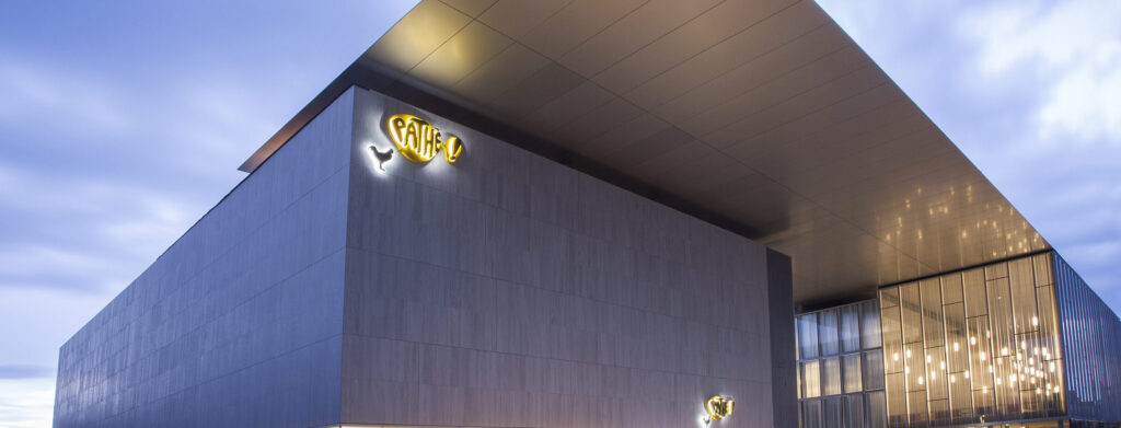 Façade extérieure du cinéma éclairée à la tombée de la nuit.