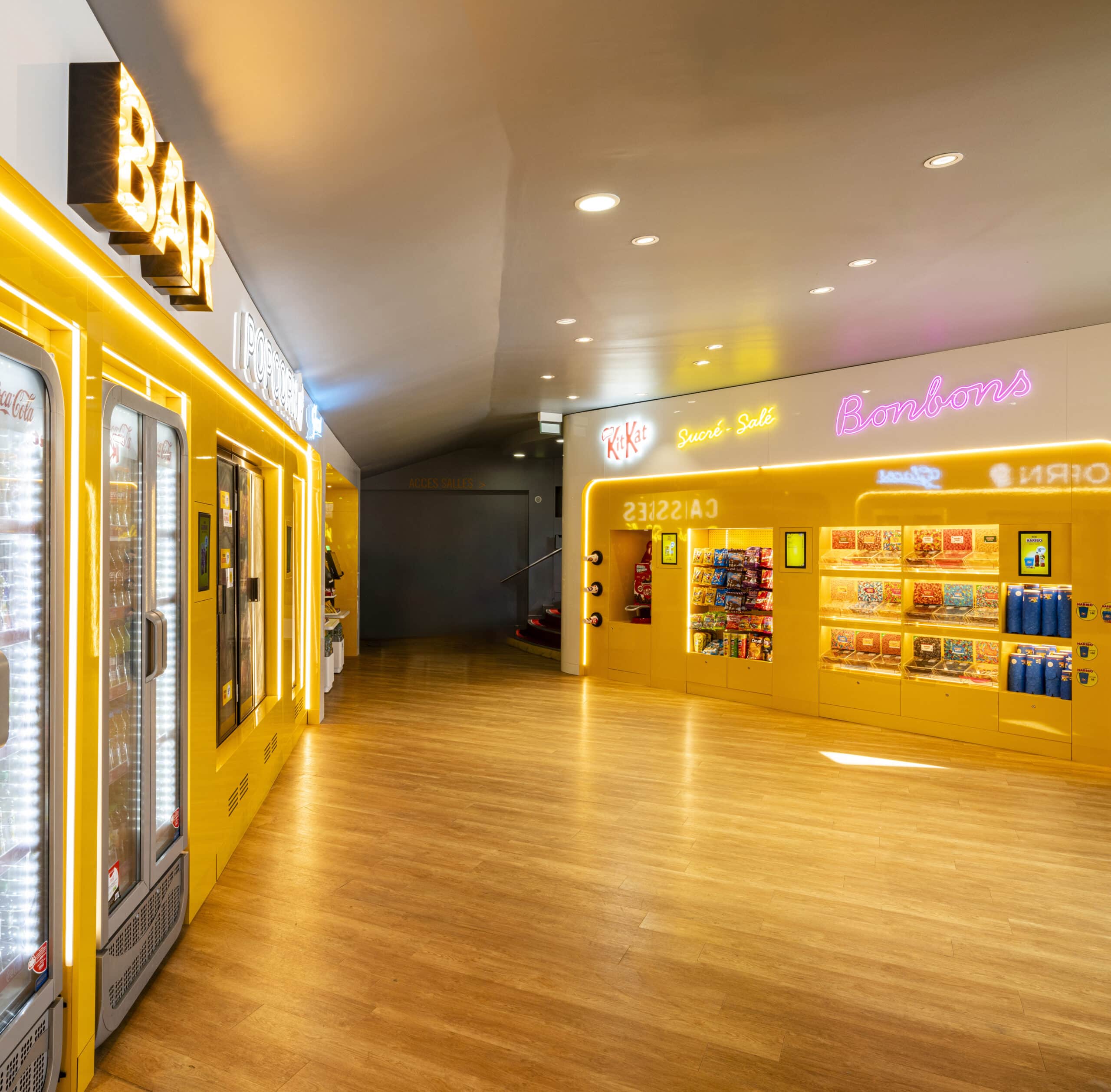 Espace confiserie du cinéma Pathé avec comptoir de pop-corn, distributeurs de boissons en libre-service.
