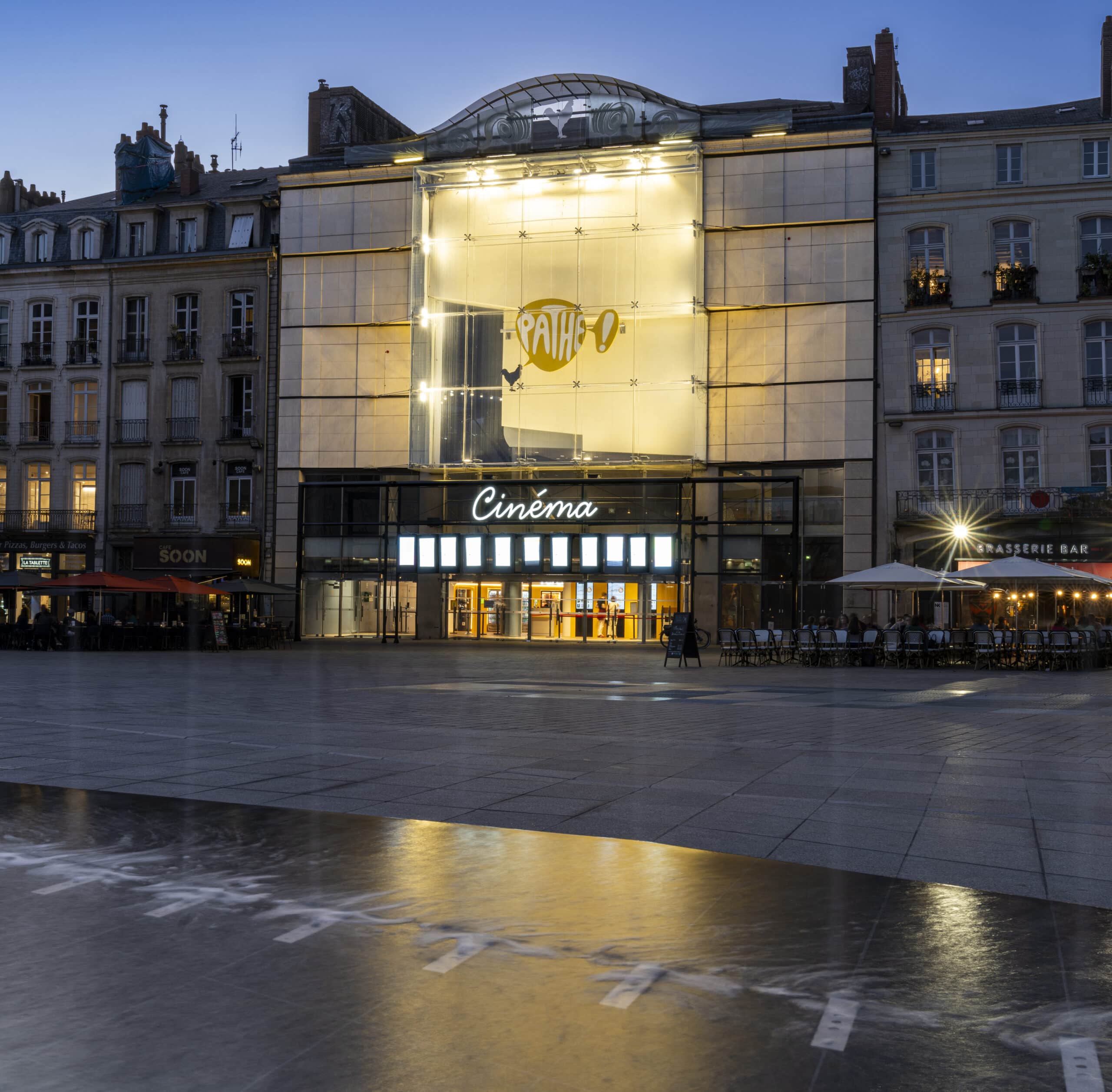 Façade extérieure du cinéma illuminée à la tombée de la nuit.