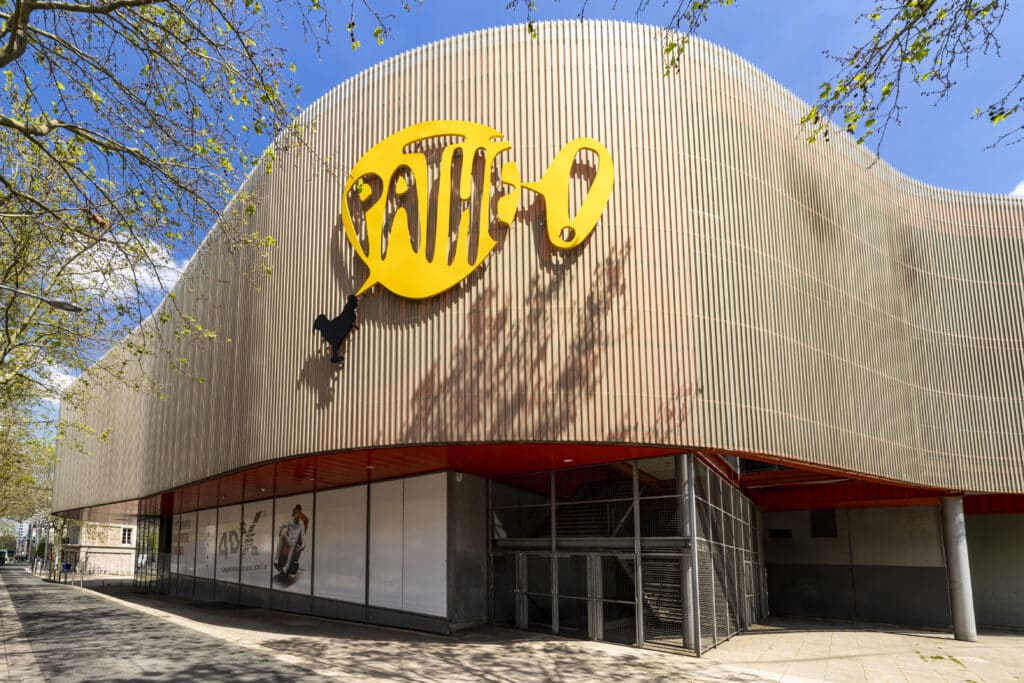 Façade extérieure du cinéma à la lumière du jour avec le logo Pathé apparent.