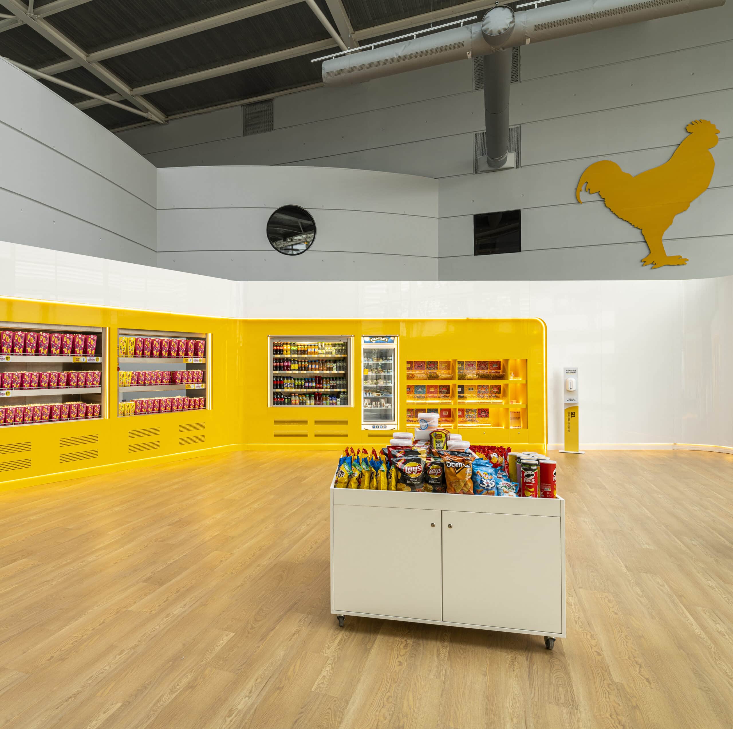 Espace confiserie du cinéma Pathé avec comptoir de pop-corn, distributeurs de boissons en libre-service et îlots de snacks et confiseries.
