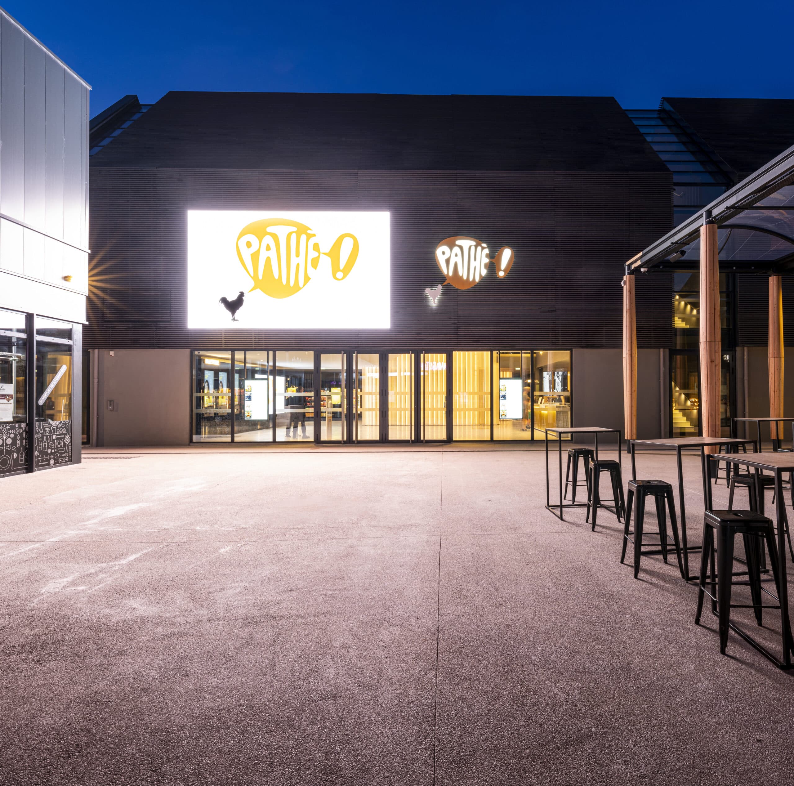 Façade extérieure du cinéma éclairée à la tombée de la nuit.