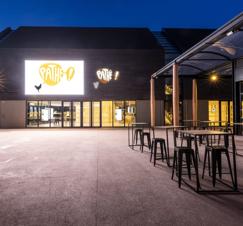 Façade extérieure du cinéma éclairée à la tombée de la nuit.