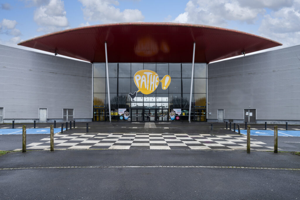Façade extérieure du cinéma à la lumière du jour avec le logo Pathé apparent.