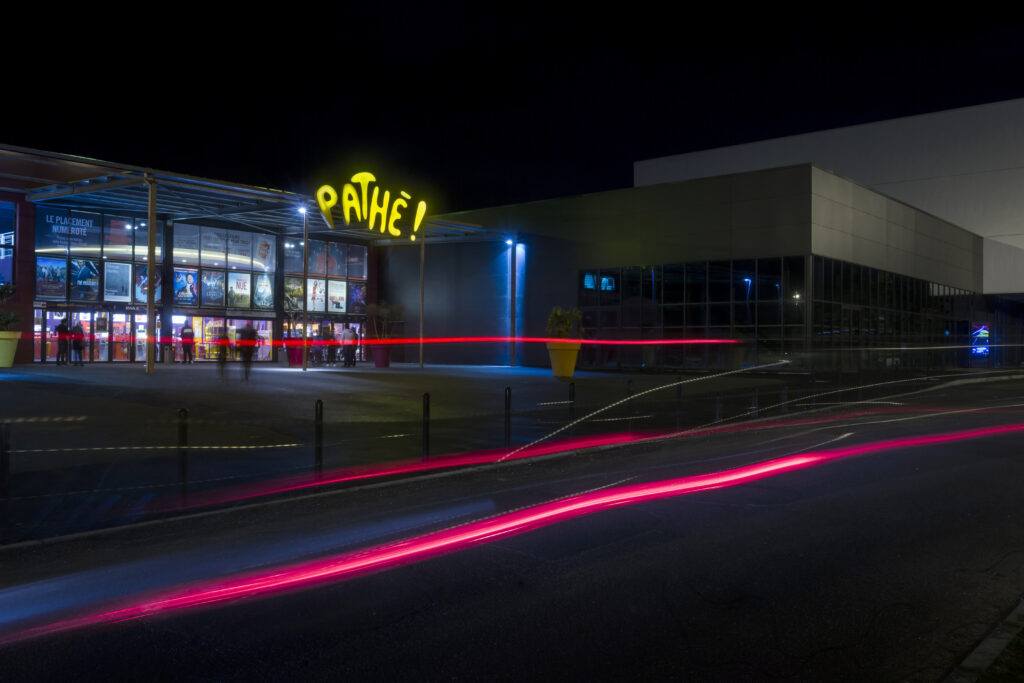 Façade extérieure du cinéma éclairée à la tombée de la nuit.