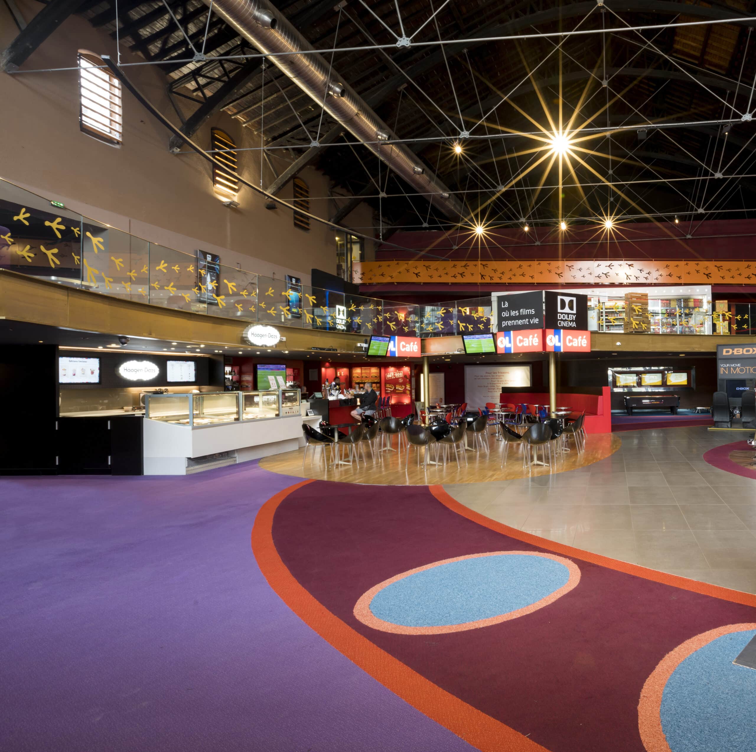 Grand espace de réception situé dans le hall du cinéma, baigné de lumière naturelle.