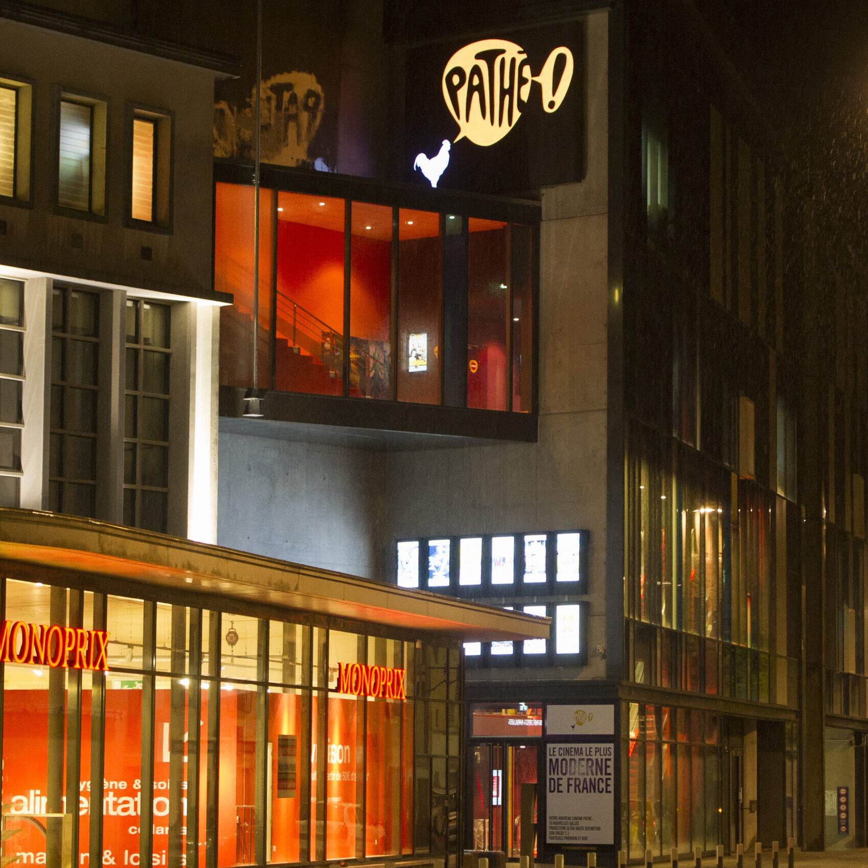 Façade extérieure du cinéma éclairée à la tombée de la nuit.