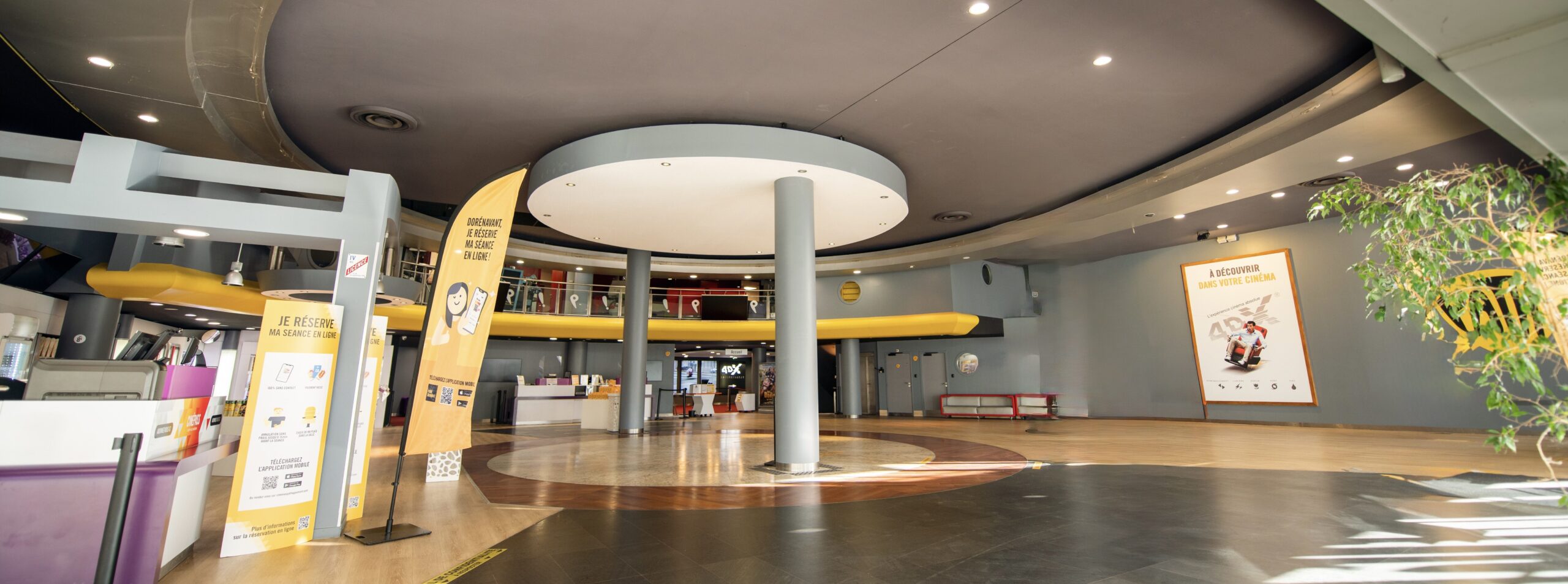 Grand espace de réception situé dans le hall du cinéma, baigné de lumière naturelle.