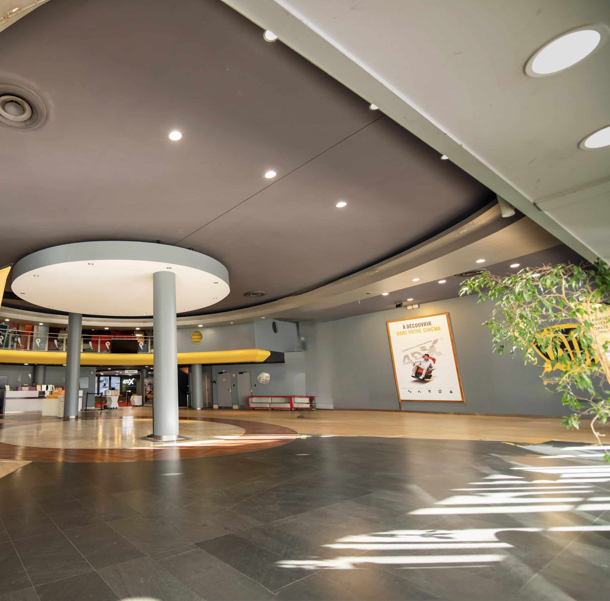 Grand espace de réception situé dans le hall du cinéma, baigné de lumière naturelle.