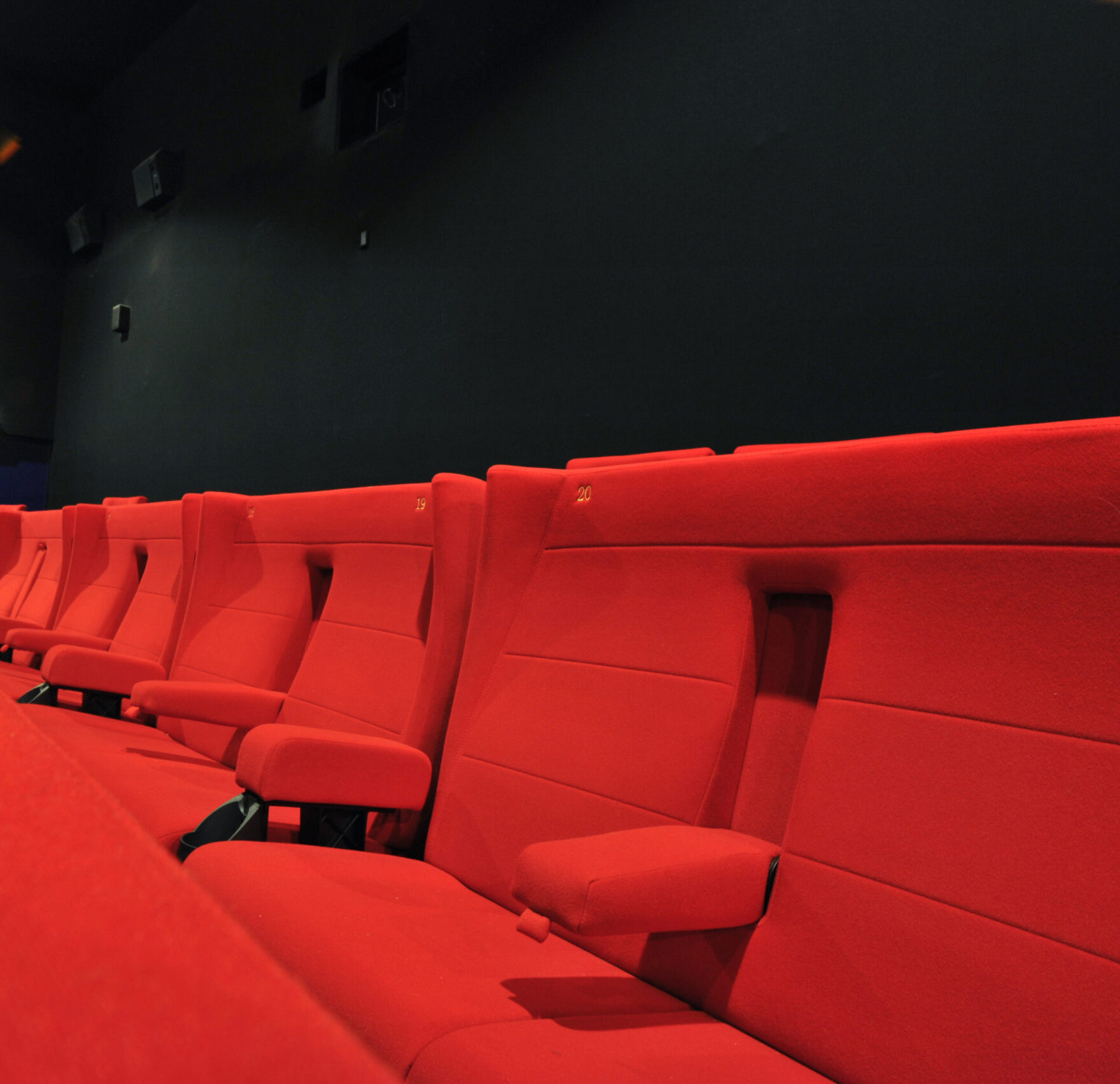 Détail du confort des fauteuils en velours rouge dans les salles de nos cinémas.