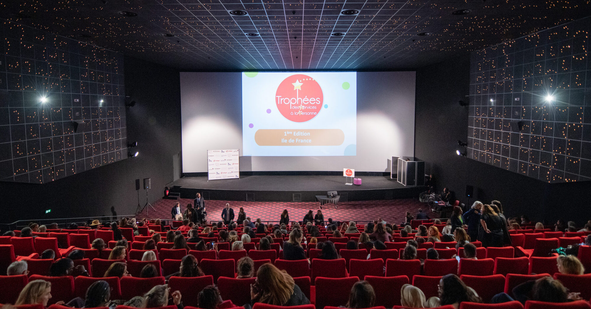 Salle de cinéma remplie de public lors d’un événement professionnel de type conférence